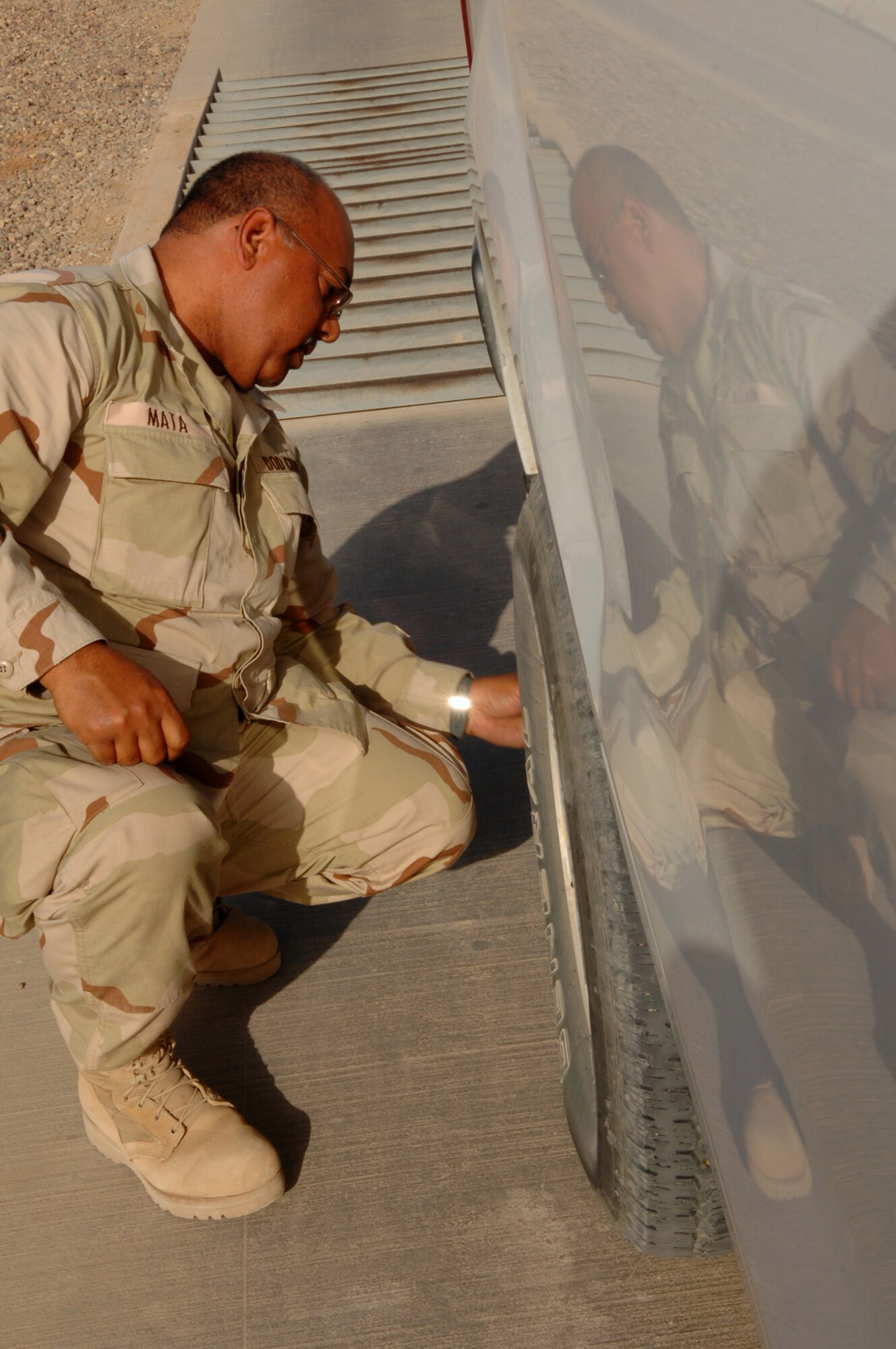 BALAD AIR BASE, Iraq -- Oseas Mata, 332nd Expeditionary Operations Support Squadron airfield manager, cleans foreign object debris from his vehicle before entering the flightline here, March 22. Mr. Mata is deployed from Offutt Air Force Base, Neb. (U.S. Air Force photo/ Senior Airman Julianne Showalter)