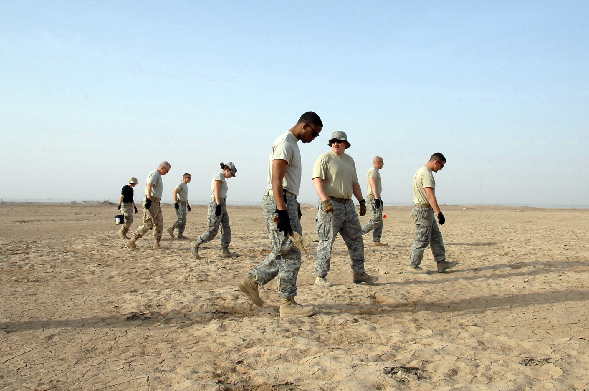 ALI Base, Iraq -- A six-Airman Explosive Ordnance Disposal team with an additional six augmentees walked through 159 acres of unexploded ordnance fields March 26.   The 407th Air Expeditionary Group members picked up debris and flagged un-removable items for detonation.  (U. S. Air Force photo / Tech. Sgt. Sabrina Johnson)