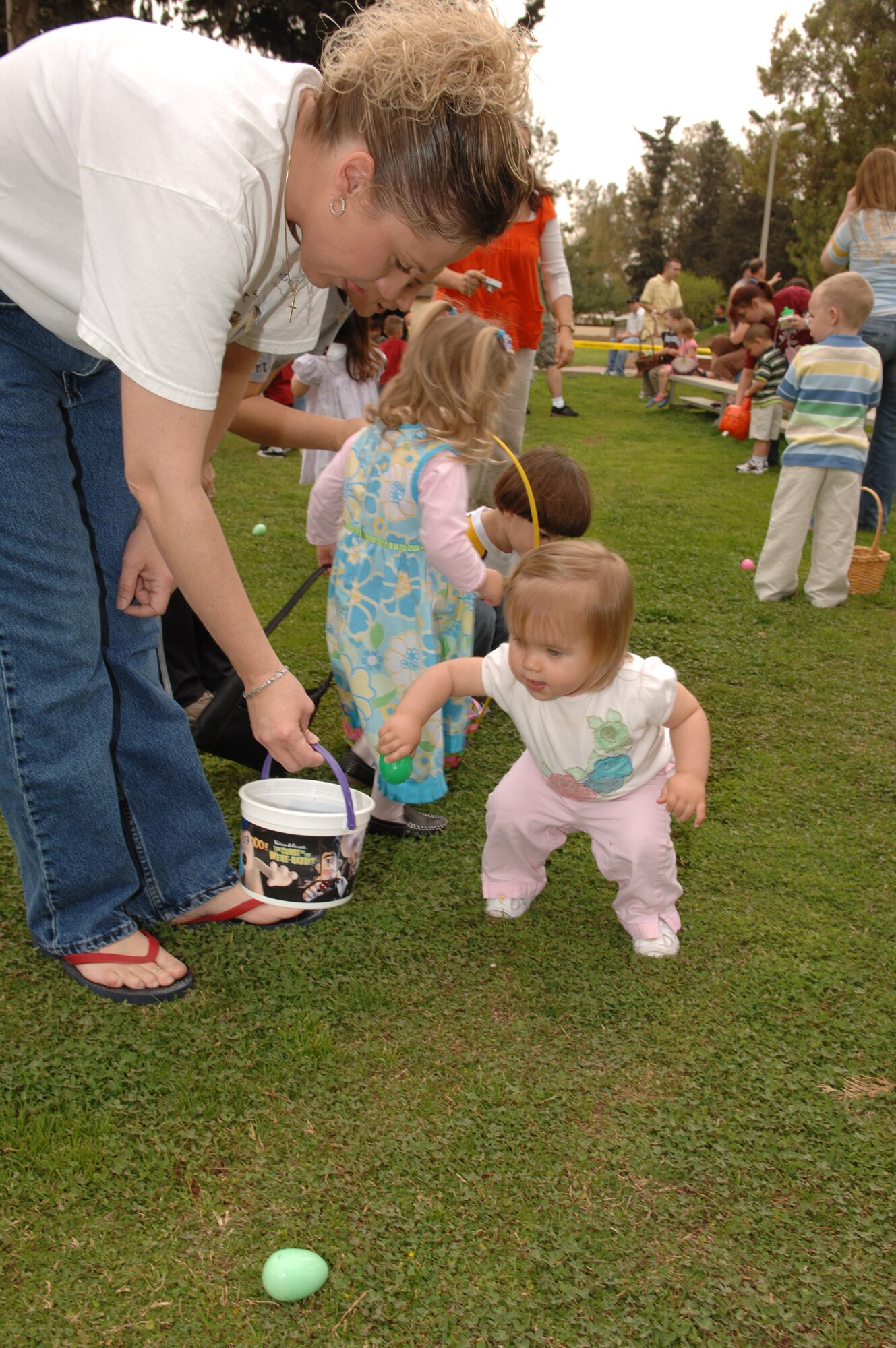 Technical Sergeant Jenelle Mankie, 39th Medical Operations Squadron, helps her 16-month-old daughter, Ayla, collect Easter eggs during the Easter egg hunt. The event was sponsored by the Youth Center and donations for the event were received from the Army and Air Force Exchange Service, the Combined Souses Club and the 728th Air Mobility Squadron. (U.S. Air Force photo by Senior Airman Jason Burton)