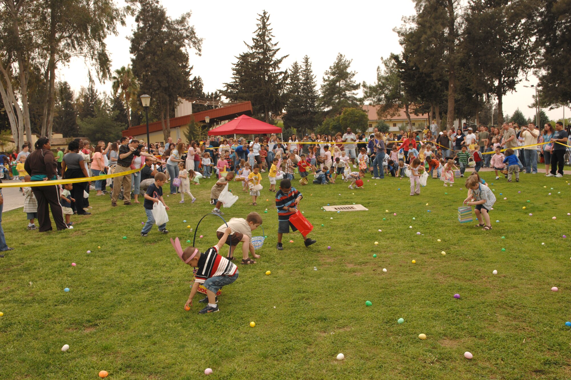 Dozens of 4-to-5 year old children rush to collect Easter Eggs during the March 22 Easter Egg hunt. The Youth Center, which sponsored the event, broke the Easter Egg hunt into separate age groups so parents with different aged children would be able to participate with each child. (U.S. Air Force photo by Senior Airman Jason Burton)
