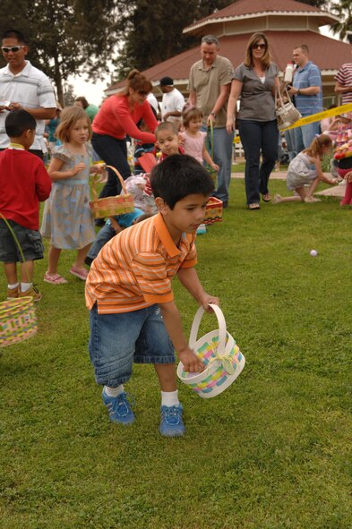 Kaden, 4, son of Staff Sgt. Erik Castilleja, 39th Communications Squadron, places his “catch” in his basket while searching for his next egg. (U.S. Air Force photo by Senior Airman Jason Burton)
