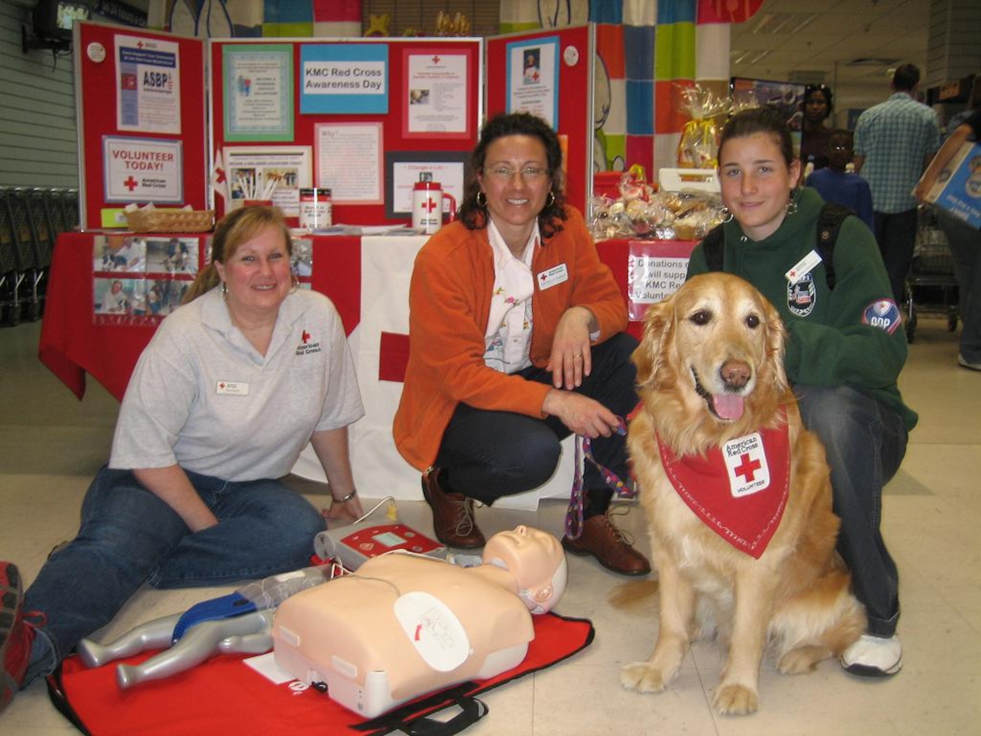Daelin Miller, Red Cross health and safety instructor (left), Raffaella Burris, Red Cross pet visitation program coordinator, and Barbara Burris, Red Cross volunteer, with her dog Toffee, promote Red Cross awareness day at the Vogelweh BX March 15. Courtesy photo