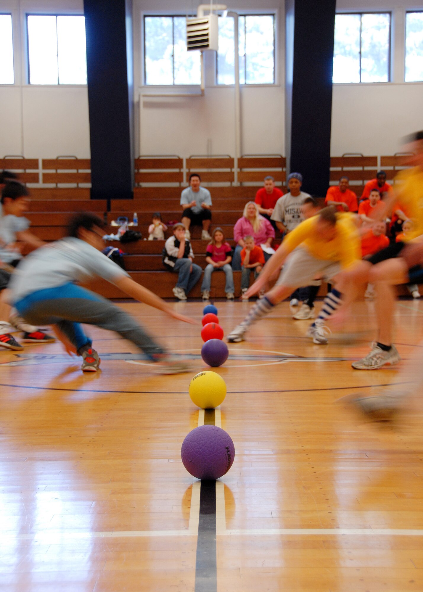 MISAWA AIR BASE, Japan -- Members of team "Mustache Samurai" (left) and "AIMD" (right) rush to the center to get a ball before the other team does during a dodgeball tournament here March 23, 2008.  A total of 10 teams competed in the tournament sponsored by the Potter Fitness Center. (U.S. Air Force photo by Senior Airman Chad Strohmeyer)