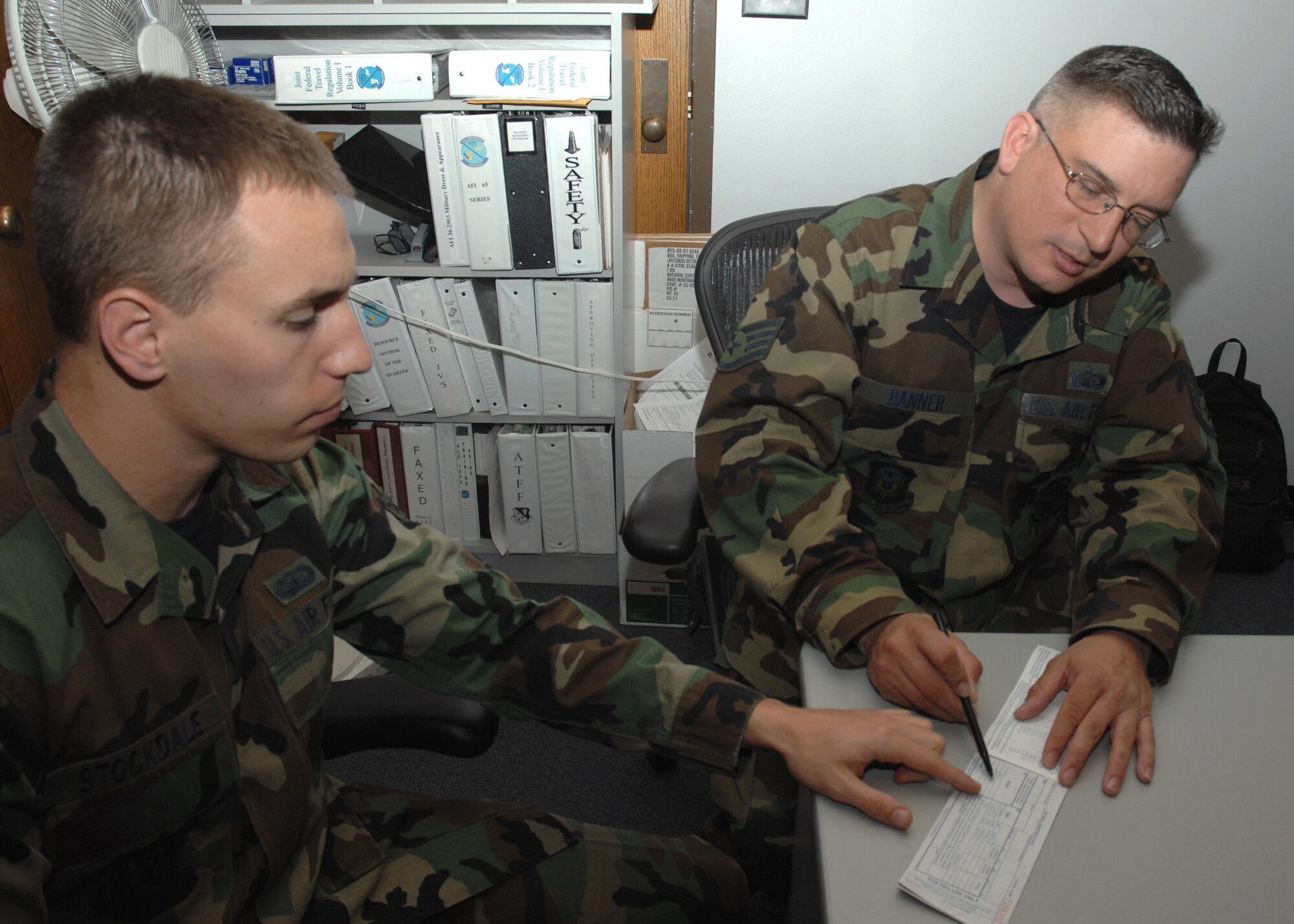 CANNON AIR FORCE BASE N.M.--Staff Sgt. Eric Banner, 27th Special Operations Comptroller Squadron, explains the Air Force Assistance Fund to Airman 1st Class Jordan Stockdale, 27 SOCPTS, on March 27. The AFAF drive takes place from March 10 to April 18. (U.S. Air Force photo Airman 1st Class Evelyn Chavez)