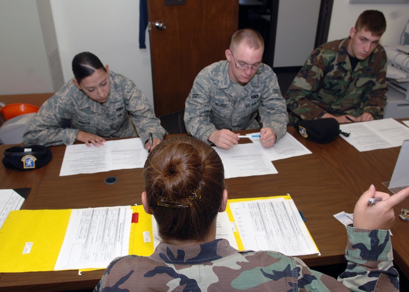 DYESS AIR FORCE BASE, Texas -- Staff Sergeant Teri Barreno briefs three First Term Airmen during their in-processing portion of the course, March 26. First Term Airmen are required to complete several in-processing forms before entering the course. (U.S. Air Force Photo by Airman 1st Class Micheal Breaux)