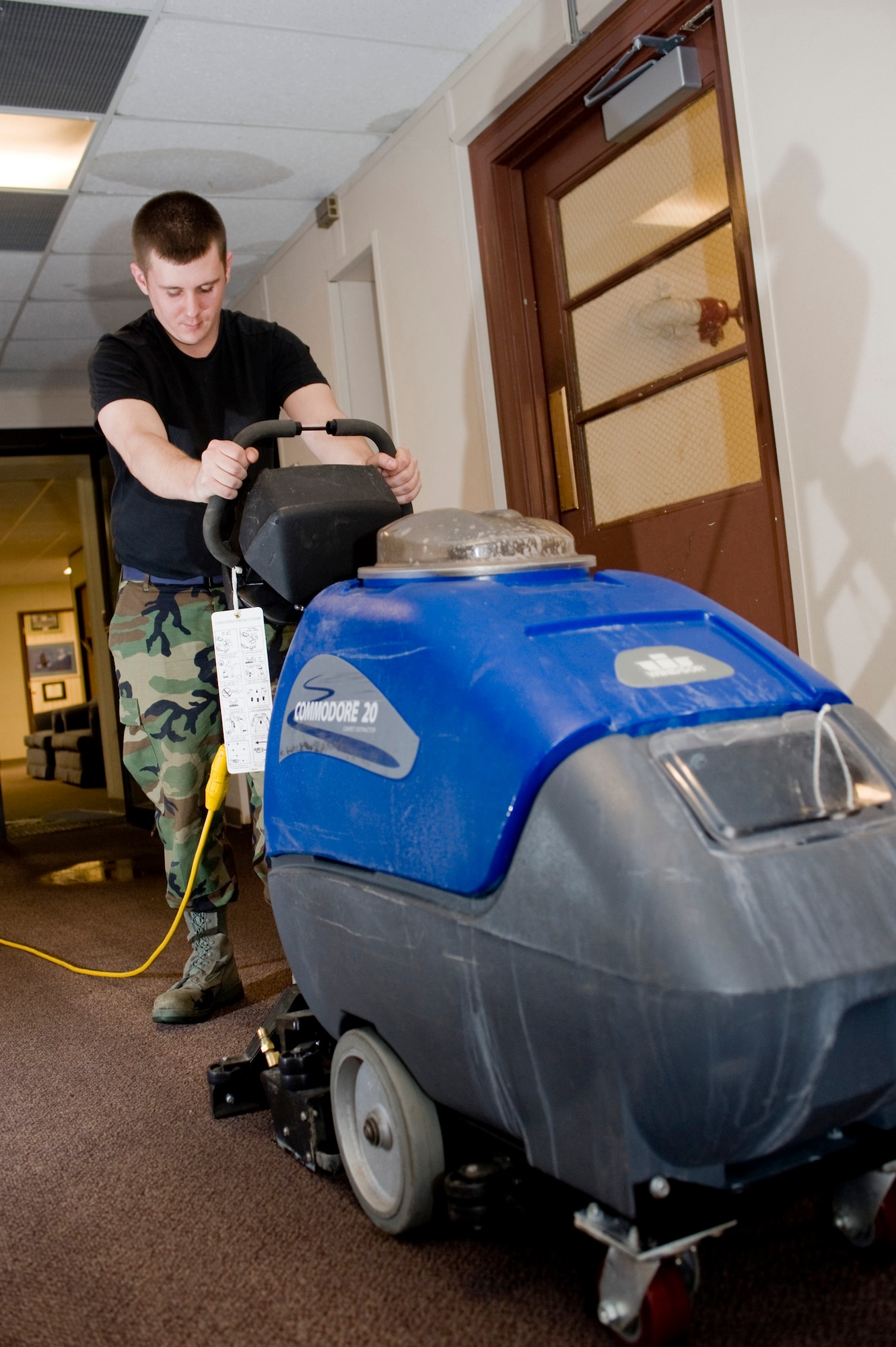 Airman Adam Pollock, 3rd Civil Engineer Squadron, vacuums with a carpet cleaner to get water off the second floor after a burst pipe. (U.S. Air Force photo by Airman 1st Class Jonathan Steffen)  