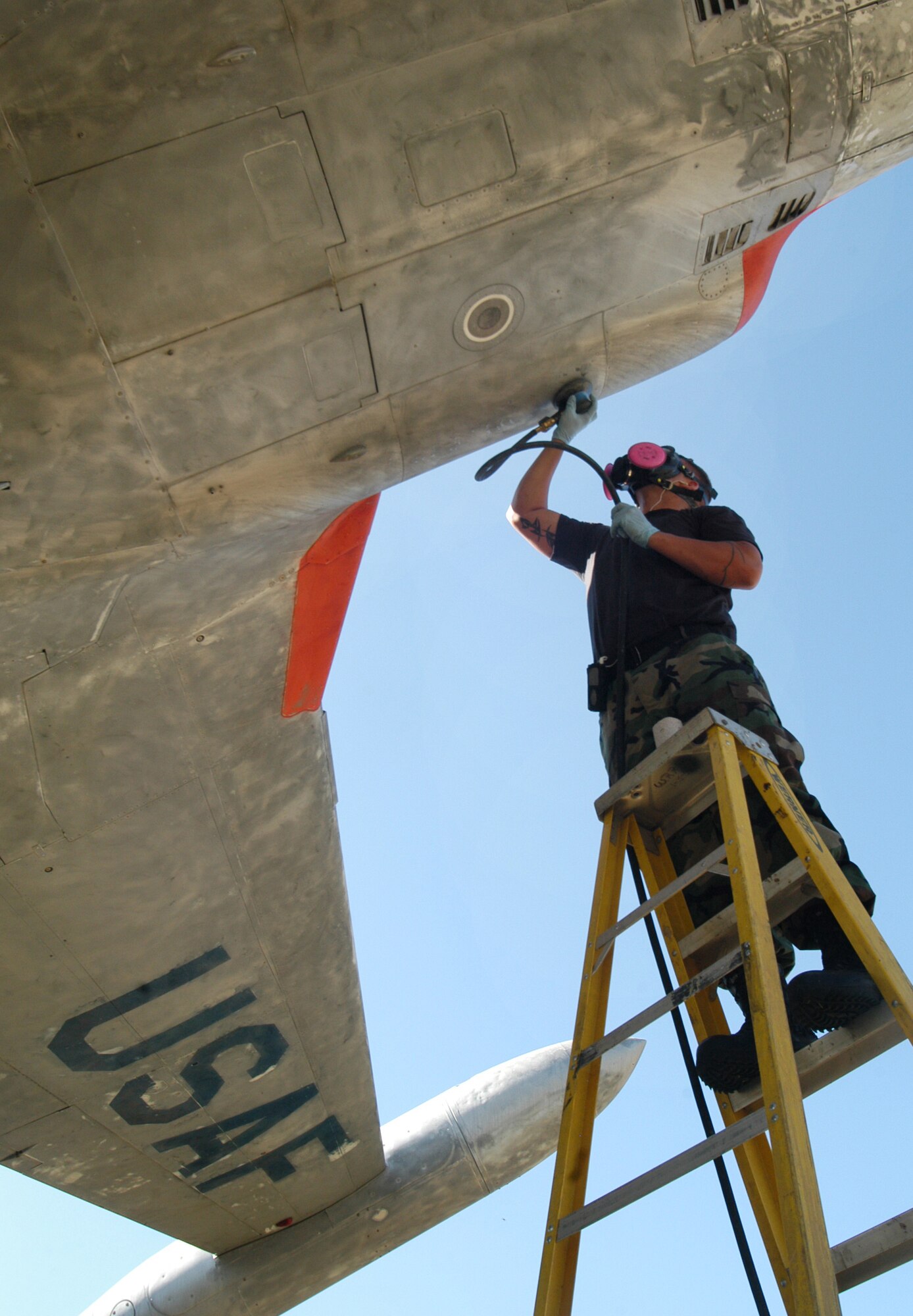 SrA Matthew Plank uses a hand sander on the TF-33 March 6 to prepare it for painting. U. S. Air Force photo by Sue Sapp     