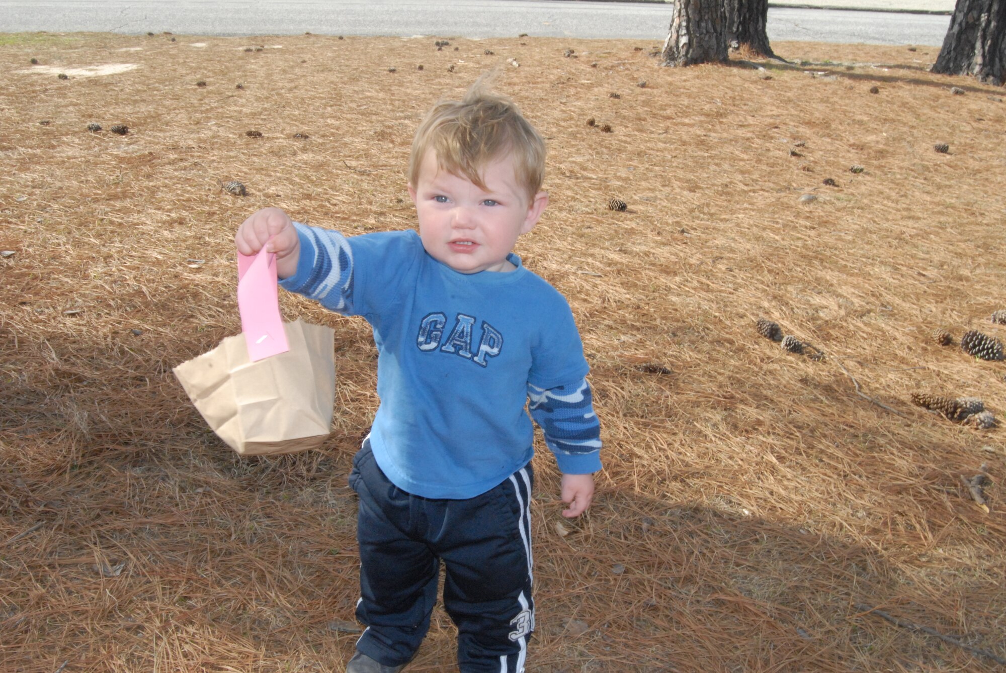 Ben, 14 months, shows the eggs he found for the Easter egg hunt outside near the back of the Pope Library March 21. The library conducted an Easter egg hunt for children of military personnel. (U.S. Air Force Photo by Airman 1st Class Mindy Bloem)