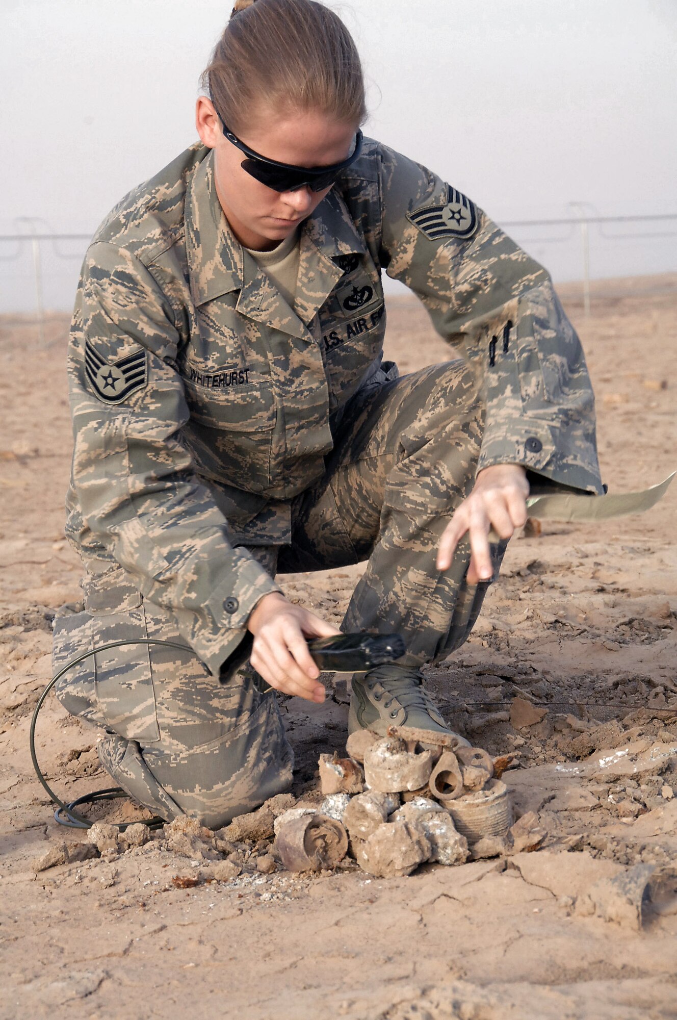 Staff Sgt. Molly Whitehurst places C4 on hazardous ordnance items to be detonated March 26 at Ali Base, Iraq. An explosive ordnance disposal team scoured 159 acres of unexploded ordnance fields picking up debris and marking un-removable items for detonation. Sergeant Whitehurst is the 407th Expeditionary Civil Engineer Squadron Explosive Ordnance Disposal team chief and is deployed from Kadena Air Base, Japan. (U.S. Air Force photo/Tech. Sgt. Sabrina Johnson) 