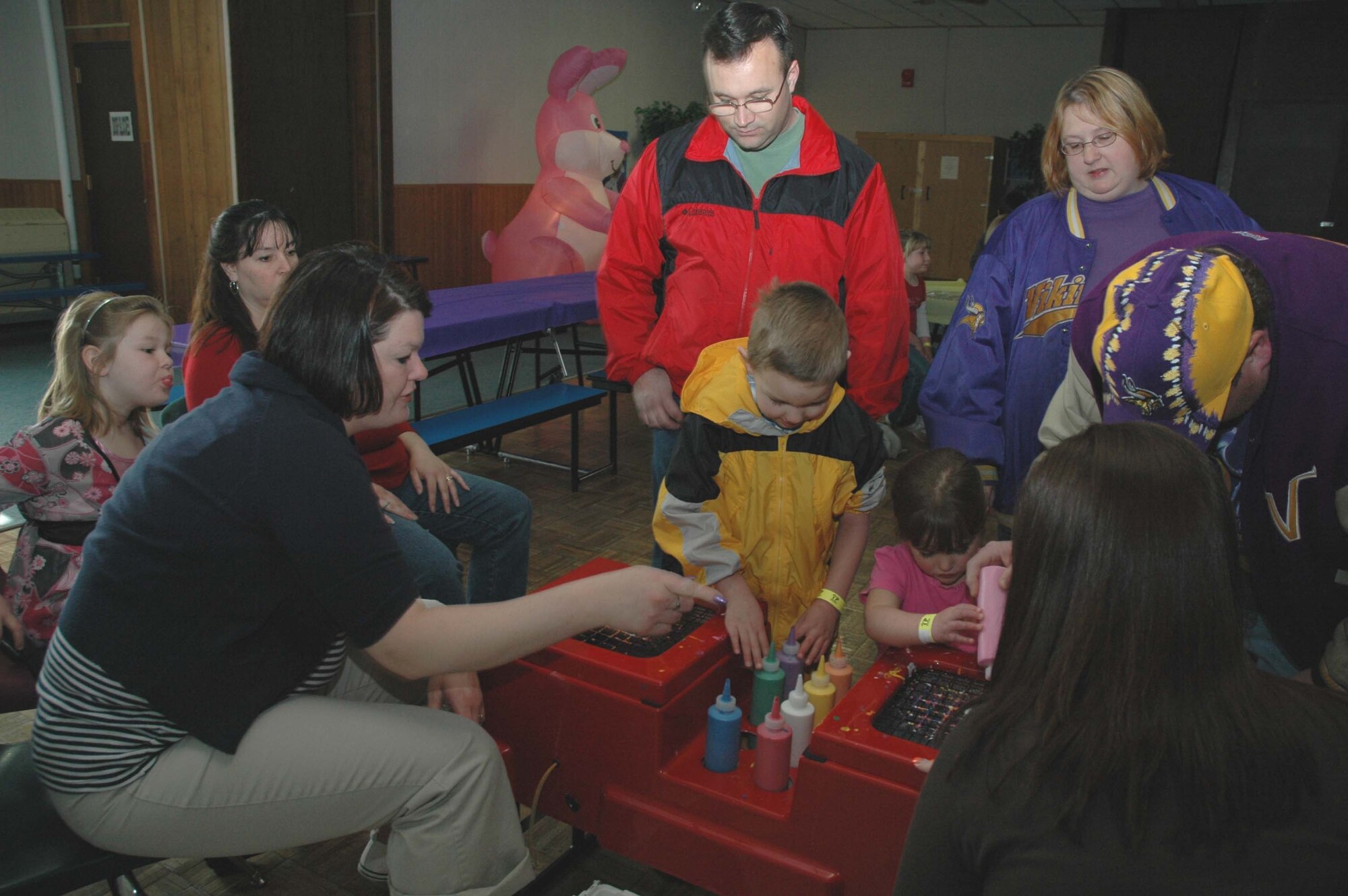 Little Warriors Christian, 6, and Meghan, 3, do spin art at the crafts table during the Youth Programs Center Spring Carnival as their parents look on. The Spring Carnival took place March 22 and featured an Easter bunny, arts and crafts, games, prizes and food. (U.S. Air Force photo/Airman 1st Class Emerald Ralston)