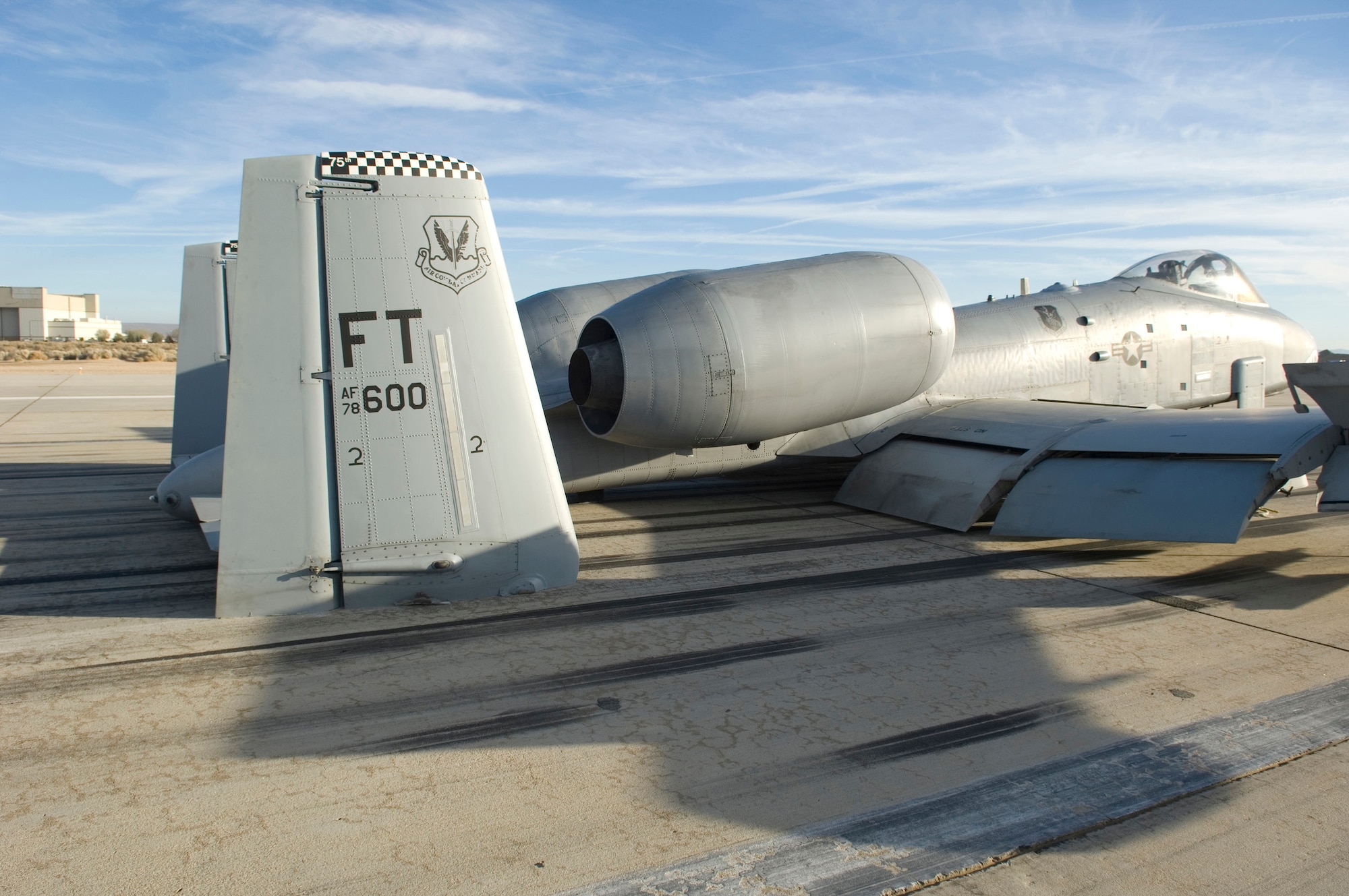 The tail section of an A-10 from the 75th Fighter Squadron at Moody Air Force Base, Ga., makes direct contact with Runway 22 after making an emergency landing here Tuesday. The A-10 landed at Edwards with its landing gear in the up position after declaring an in-flight emergency. (Air Force photo by Brad White)
