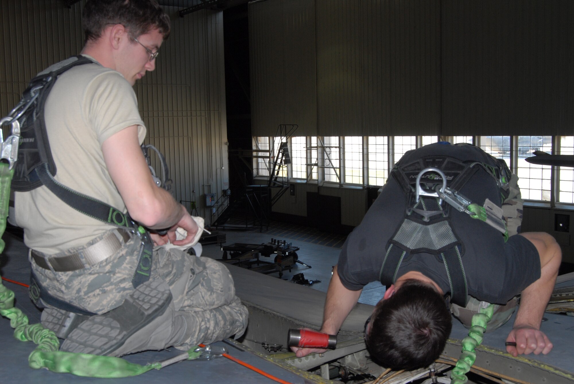 (Left) Staff Sgt. Michael Bender, 43rd Aircraft Maintenance Squadron, and Airman 1st Class Nathan Gardner, 43rd Maintenance Squadron, perform routine maintenance on the right wing of a C-130E plane March 17. (U.S. Air Force Photo by 2nd Lt. Chris Hoyler)