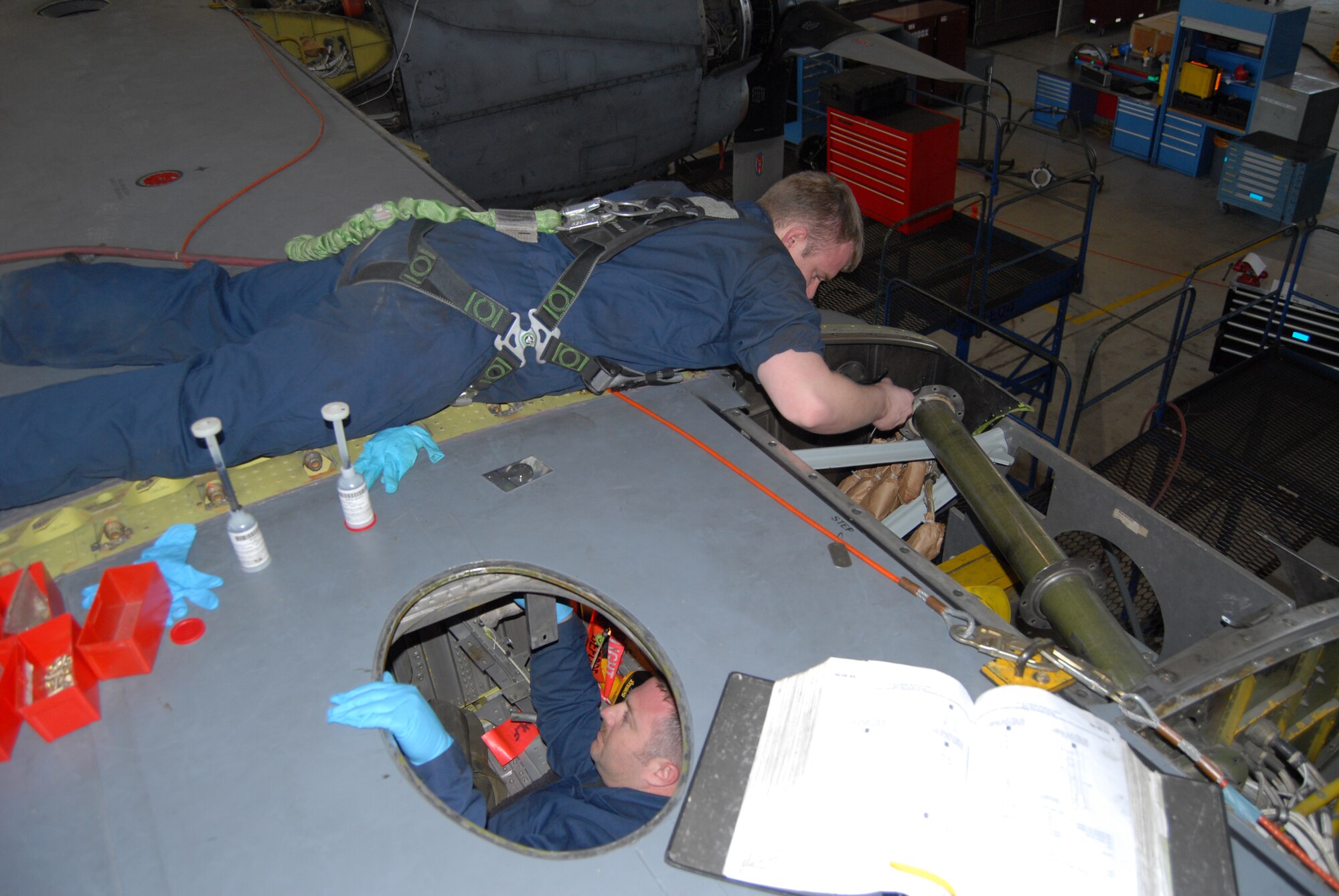 Staff Sgt. Wendell Bond, 43rd Maintenance Squadron, and Staff Sgt. Gerald Christian, 440th Maintenance Squadron, work together on a truss mount change on the left wing of a 43rd Airlift Wing C-130 E-model plane March 17. (U.S. Air Force Photo by 2nd Lt. Chris Hoyler)