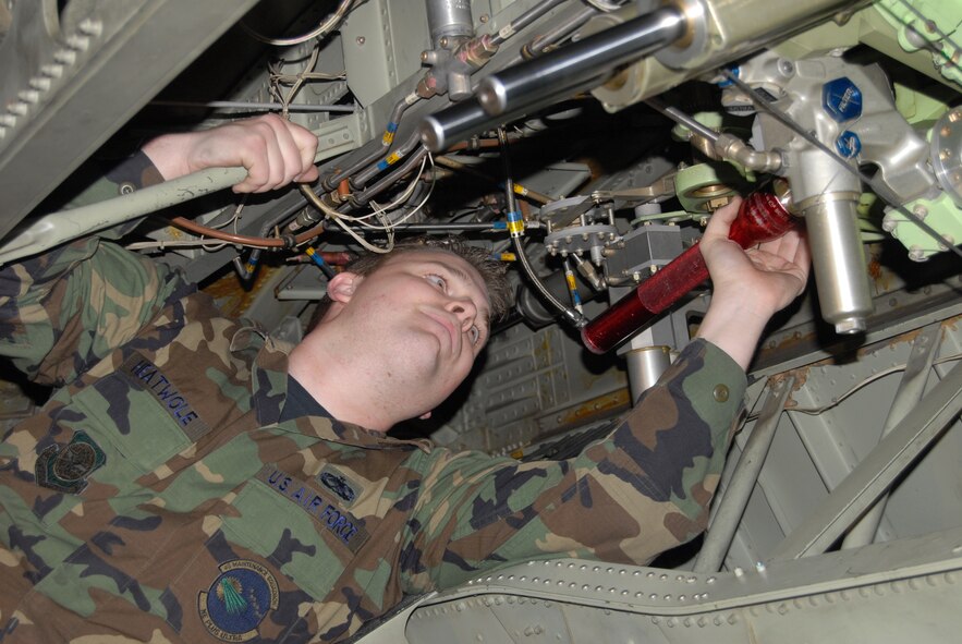 Staff Sgt. Scott Heatwole, 43rd Maintenance Squadron, gets underneath the wires in one of the 440th Airlift Wing's C-130 H-model aircraft during a preliminary inspection in hangar six Monday. 43rd and 440th MXS Airmen are working together on maintaining both 43rd AW E-model and 440th AW C-130Hs everyday on Pope. (U.S. Air Force Photo by 2nd Lt. Chris Hoyler)