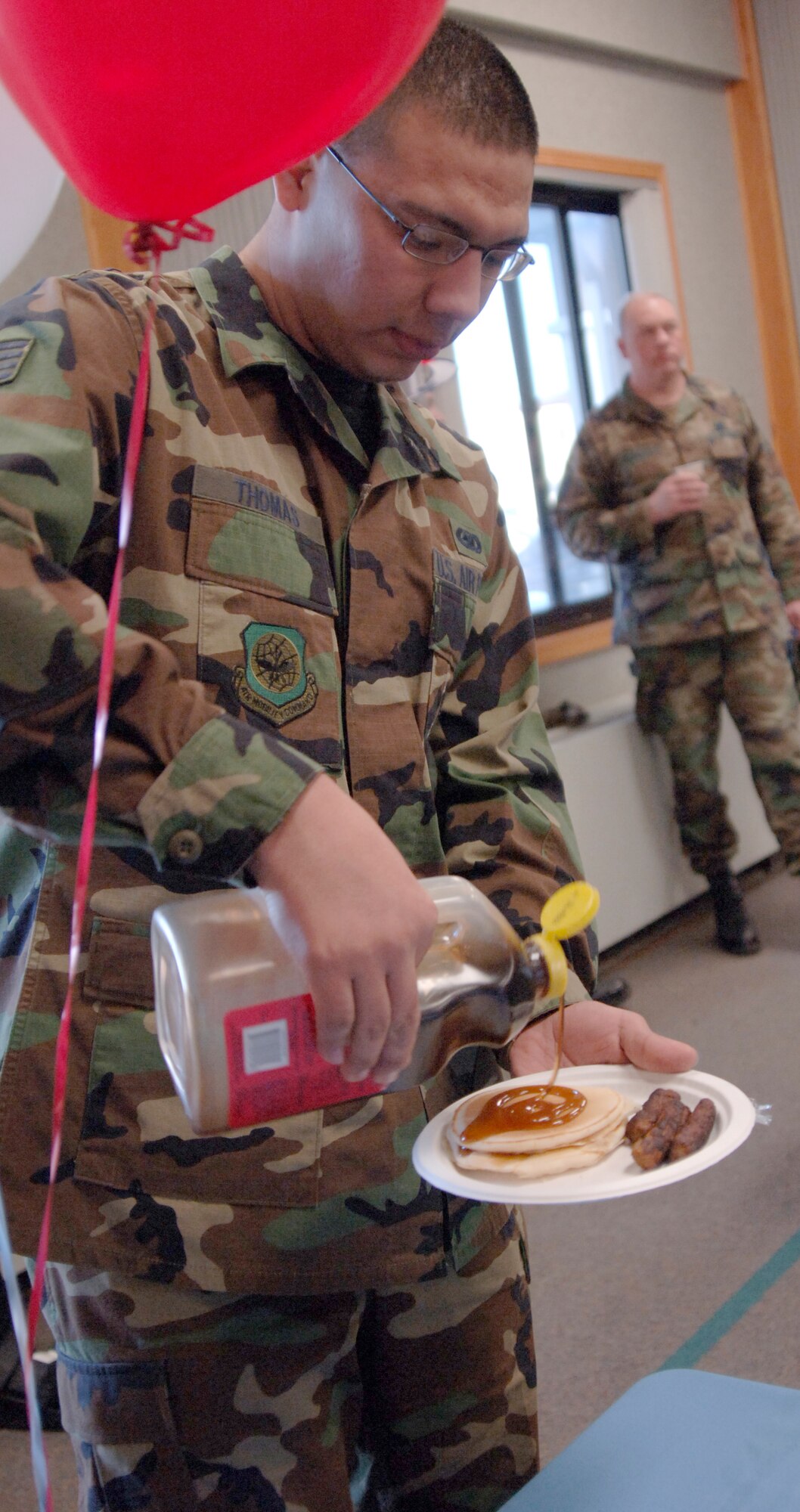 MCCONNELL AIR FORCE BASE, Kan. – Master Sgt. Keena Bassi, 22nd Maintenance Operation Squadron First Sergeant, serves hot pancakes and sausage to Staff Sgt. Gaston Dorador, 22nd Logistics Readiness Squadron, at the Chapel Annex, March 25. A pancake and sausage breakfast kicked of the Air Assistance Fund campaign here, which is scheduled through May 2. (Photo by Senior Airman Roy Lynch III) 
