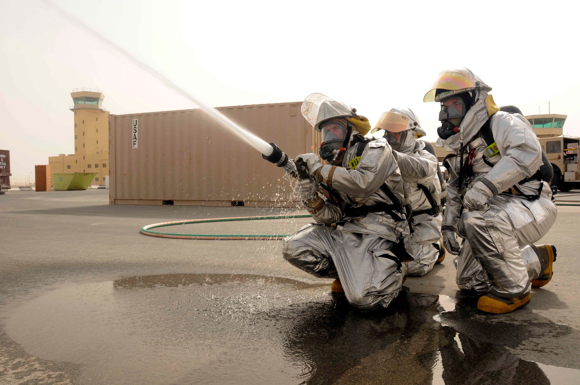 Senior Airman Thomas Mix, Airman First 1st Class Matthew Salyers, and Airman 1st Class Charles McKenzie use a high pressure water hose to extinguish a simulated fire March 20. (U.S. Air Force photo/ Senior Airman Domonique Simmons)
