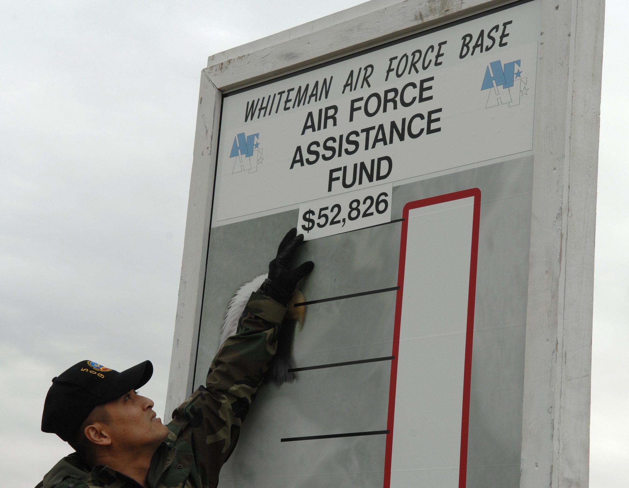 WHITEMAN AIR FORCE BASE, Mo. - Senior Master Sgt. Marlon Galbadores, 509th Maintenance Squadron puts  this year’s Whiteman Air Force Base Air Force Assistance Fund campaign goal of $52,826 on the Whiteman AFAF thermometer at the Spirit Gate March 26. The campaign kicks off March 26 and runs through May 22.  The campaign raises money for four charities that directly support Air Force personnel and their families. The charities are: Air Force Aid Society , the General & Mrs Curtis E. LeMay Foundation, the Air Force Village Indigent Widows’ Fund and the Air Force Enlisted Village Indigent Widows’ Fund. (U.S. Air Force photo/Airman 1st Class Stephen Linch)
