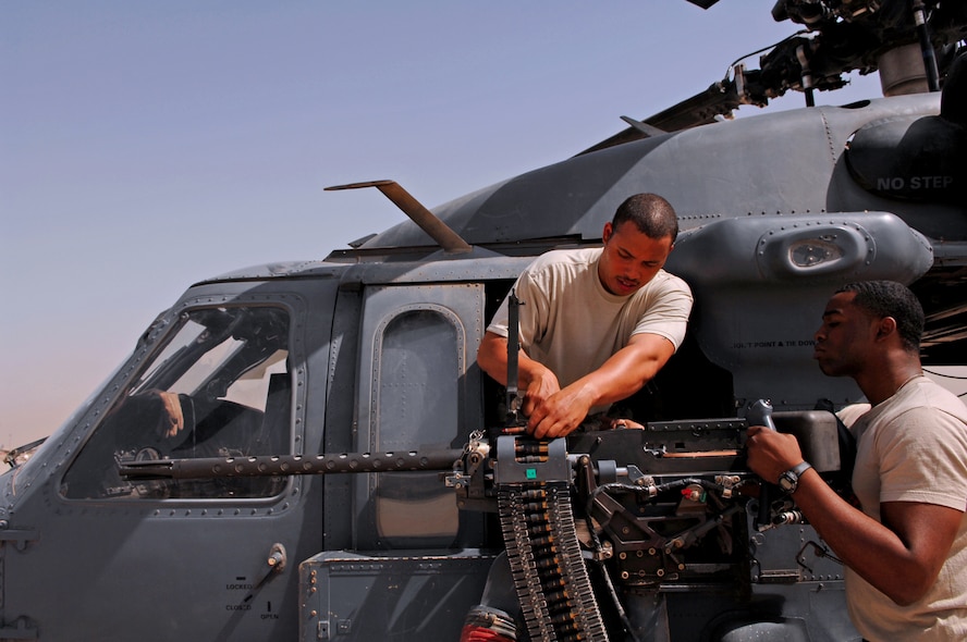 BALAD AIR BASE, Iraq -- Senior Airmen Derand Javier and Chris Moore, 64th Aircraft Maintenance Unit weapons specialists, test the head spacing of a .50-caliber machine gun on an HH-60G Pave Hawk helicopter. Head spacing is the timing at which the rounds flow through the machine gun. Both Airmen are deployed from Moody Air Force Base, Ga. (U.S. Air Force photo\ Senior Airman Julianne Showalter)