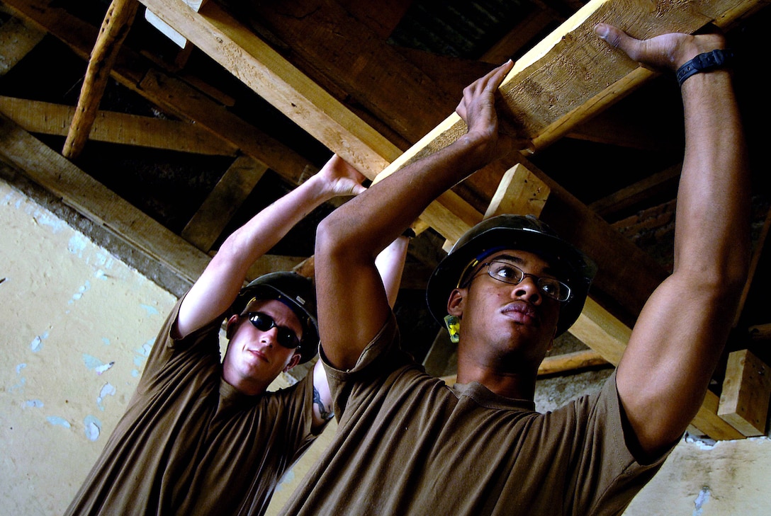U.S. Navy Petty Officer 3rd Class Clifton Ammons and Seaman Patrick Dixon both assigned Naval Mobile Construction Battalion 74, hold a piece of wood being nailed into place for a drop ceiling being installed in a classroom at Abadir Primary School, Addis Ababa, Ethiopia, March 18, 2008.  