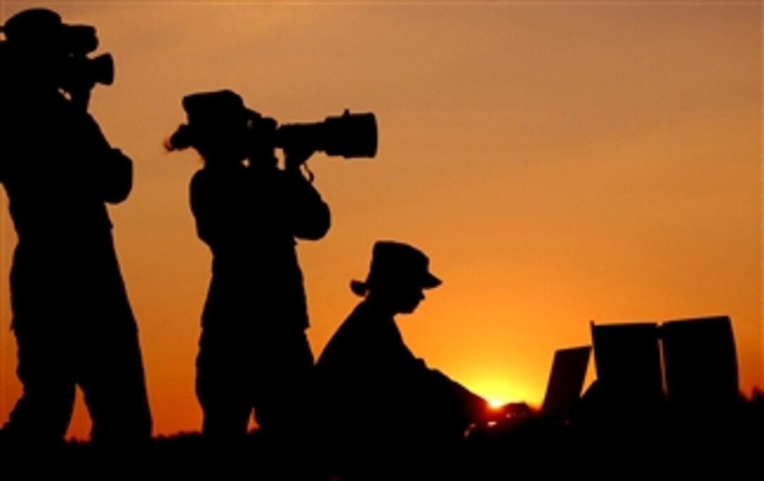 A U.S. Air Force videographer, left, a still photographer and a graphics specialist are backlighted by the setting sun. The airmen earned 13 first place awards, nine second place awards and 11 third place awards in the Defense Department 2007 Visual Information Awards contest, which was judged at Fort Meade, Md., March 11-12, 2008. 