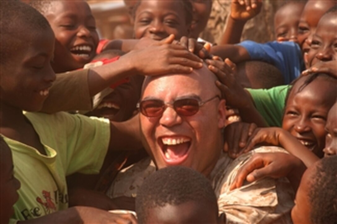 U.S. Marine Maj. Jason P. Smith takes time away from convoy operations to play with some Liberian children during a mission to deliver humanitarian supplies throughout the city of Monrovia, Liberia, March 25, 2008. Smith is assigned to the 4th Landing Support Battalion's 4th Marine Logistics Group.
