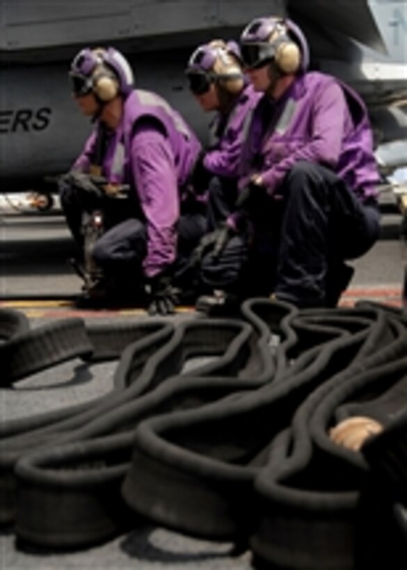Flight deck crewman assigned to Air Department's V-4 division stand by to hot-pump an aircraft on the flight deck of the aircraft carrier USS Abraham Lincoln (CVN 72) as the ship operates in the Pacific Ocean on March 26, 2008.  Hot pumping is refueling the aircraft while the engines are still running.  