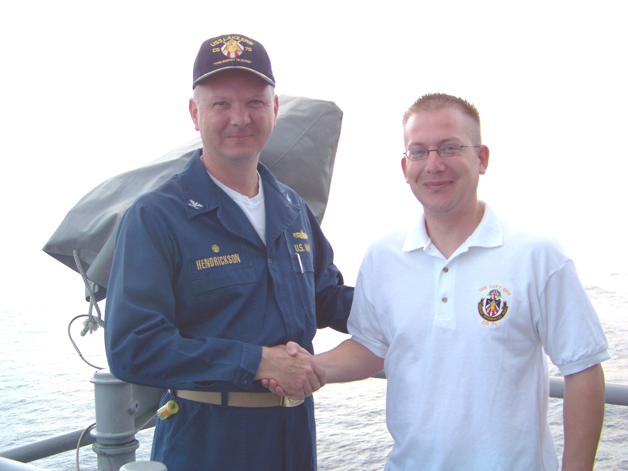 Navy Capt. Randall Hendrickson, the Lake Erie’s commanding officer (left), congratulates Byron Koomia on a job well done. Koomia, an engineer with Raytheon based in Tucson, Ariz., is also an Air Guardsman assigned to the 162nd Figher Wing. (U.S. Navy Photo)