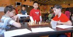 Kevin Ruiz (left) studies his next move against opponent Josiah Ferguson (right) during the Randolph Chess Tournament March 1. Christopher Phan (center) watches the match. (U.S. Air Force photo by Steve White)
