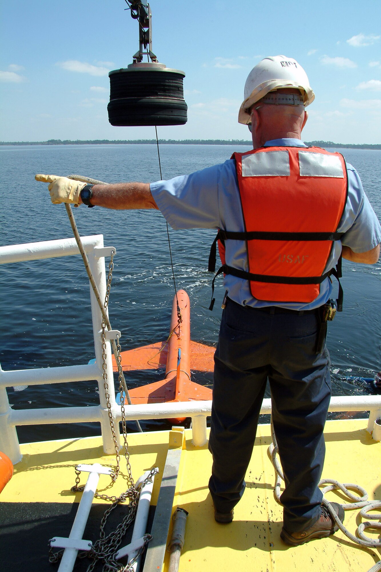 Byron Howle directs the crane movements to pick up the model BQM-107 sub-scale drone during a recovery demonstration March 26 in the waters off of Tyndall Air Force Base, Fla. The ship, one of three 120-foot boats owned by the Air Force, is contracted through the 82nd Aerial Targets Squadron to help recover sub-scale drones after they are shot down during live fire exercises. (U.S. Air Force photo/Staff Sgt. Samuel King Jr.) 