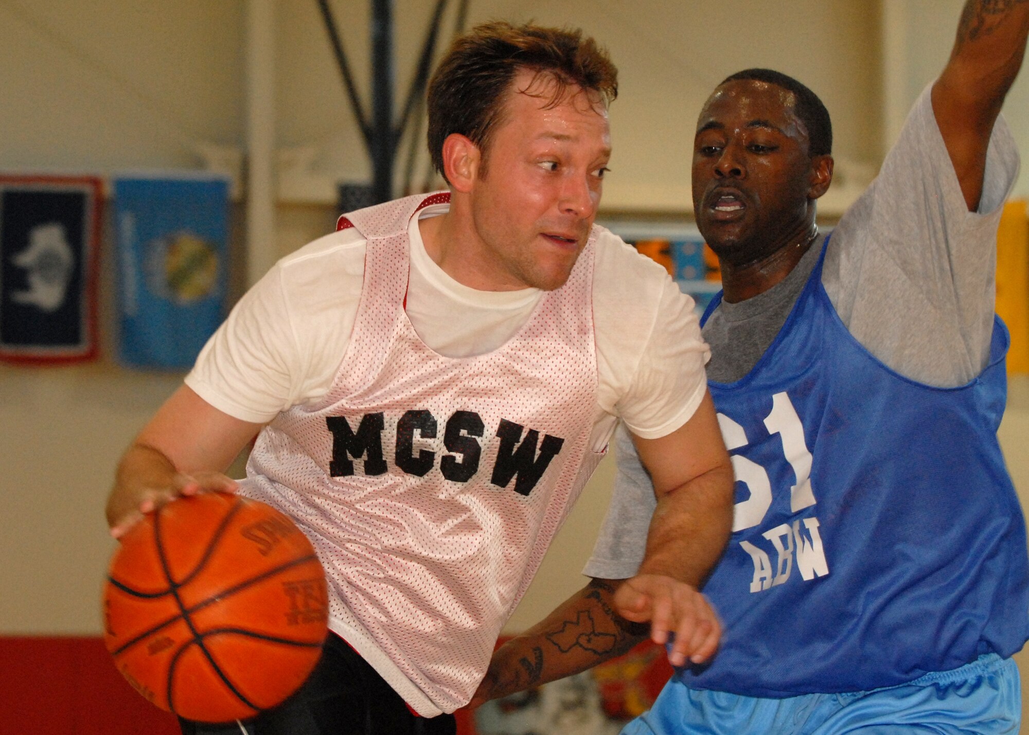 Scott Gribben, MCSW, attempts to dribble around Staff Sgt. Louis Moore, 61st ABW, during the Intramural Basketball championship game, March 27.  The Air Base Wing took the title with a 43 to 42 win. (Photo By Stephen Schester)