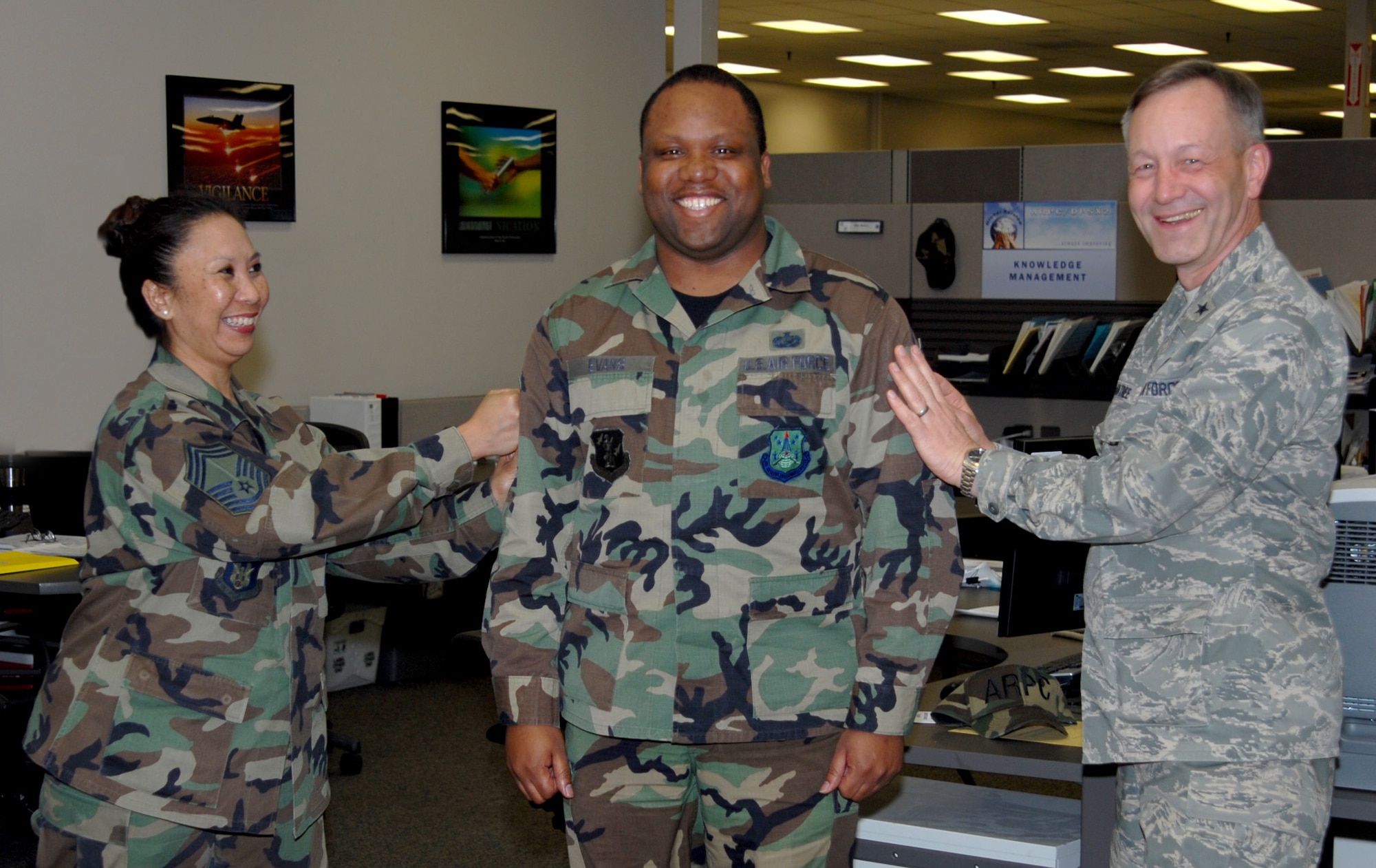 Tech. Sgt. Eric Evans, DPS, is tacked by Brig. Gen. Eric Crabtree (right), ARPC commander, and Chief Master Sgt. Fatima Jones, DPS, in the contact center March 27. Sergeant Evans is one of several ARPC Airmen who will be promoted at an official ceremony March 31. (U.S. Air Force photo/Ellen Edwards)