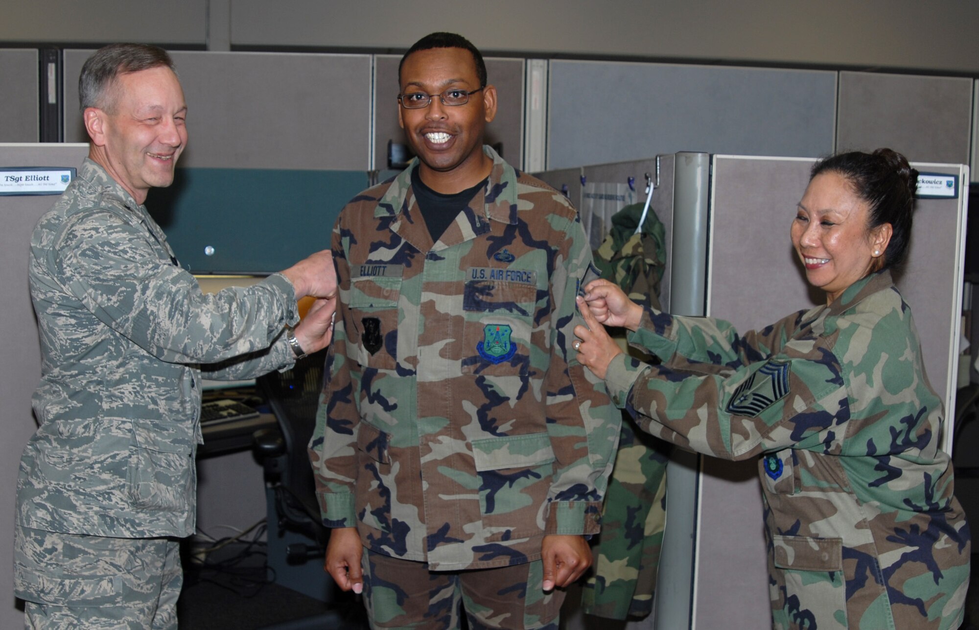 Tech. Sgt. Langston Elliott, DPS, is tacked by Brig. Gen. Eric Crabtree (left), ARPC commander, and Chief Master Sgt. Fatima Jones, DPS, in the contact center March 27. Sergeant Elliott is one of several ARPC Airmen who will be promoted at an official ceremony March 31. (U.S. Air Force photo/Ellen Edwards)