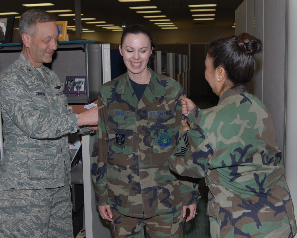 Staff Sgt. Shannon Elliott, DPS, is tacked by Brig. Gen. Eric Crabtree (left), ARPC commander, and Chief Master Sgt. Fatima Jones, DPS, in the contact center March 27. Sergeant Elliott is one of several ARPC Airmen who will be promoted at an official ceremony March 31. (U.S. Air Force photo/Ellen Edwards)