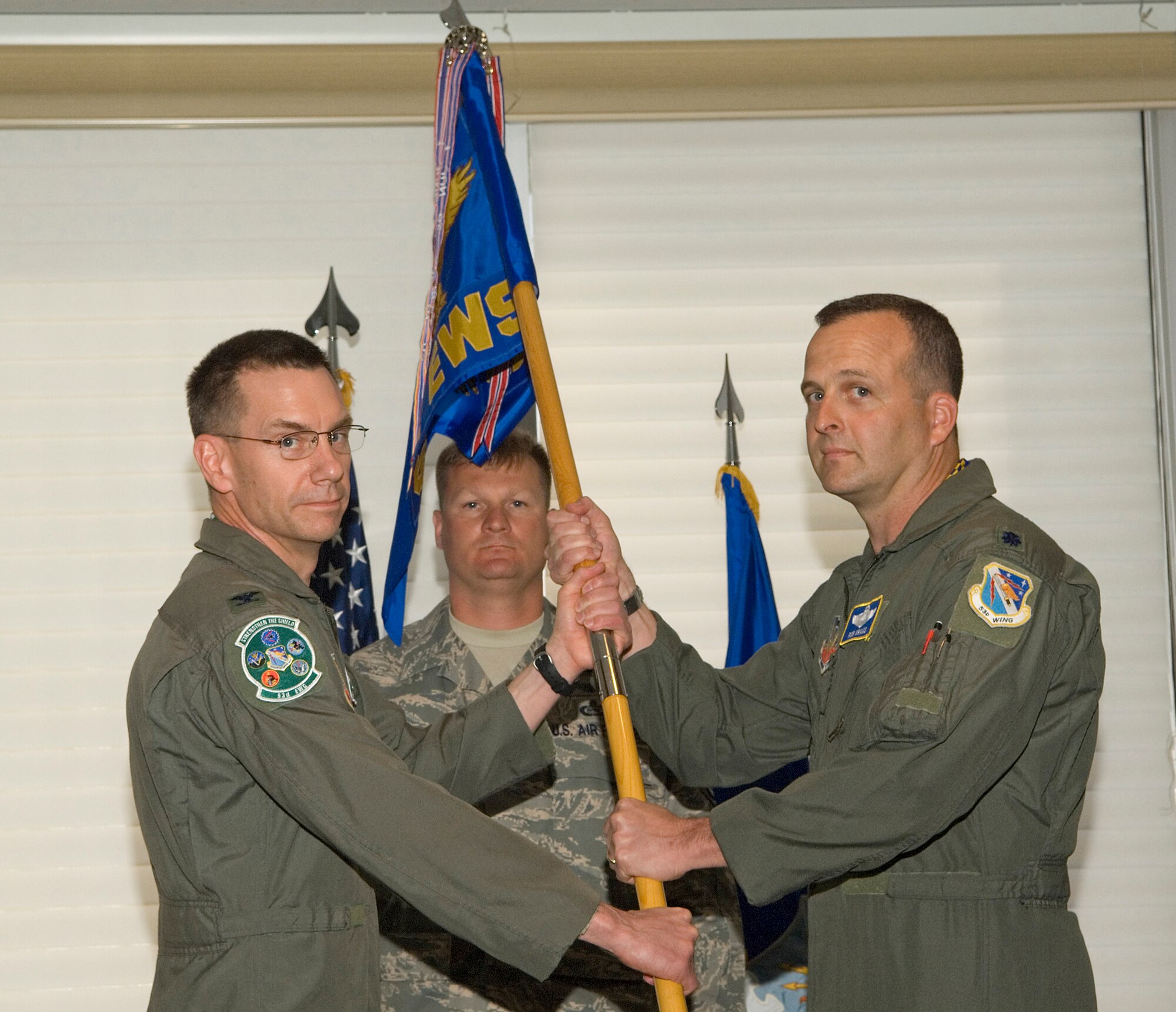 Col. Greg Dragoo, 53d Electronic Warfare Group commander, hands over the 68th Electronic Warfare Squadron guidon to it new commander, Lt. Col. Rob Kraus at the change of command ceremony March 27 at the officers club at Eglin Air Force Base, Fla.  Colonel Kraus took the reins of the 68th from Lt. Col. Gene Anderson.  Courtesy photo.