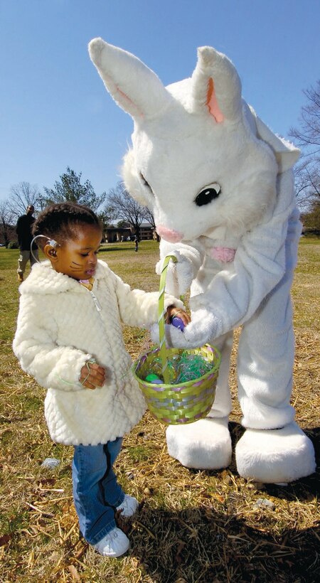 Taylor Hannah, 2, recieves an Easter egg from the Easter Bunny during an Easter egg hunt outside of the 1st and 99th Airlift Squadrons, squadron operations building on March 21. The event was sponsored by the 89th Communications Squadron and treated families to actvities such as face painting, games, coloring for children, food and refreshments. Taylor is the daughter of Staff Sgt. Tywone Hannah, an 89 CS wide ban technician. (US Air Force/Bobby Jones)