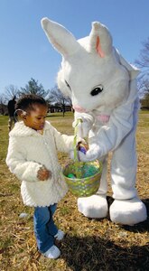Taylor Hannah, 2, recieves an Easter egg from the Easter Bunny during an Easter egg hunt outside of the 1st and 99th Airlift Squadrons, squadron operations building on March 21. The event was sponsored by the 89th Communications Squadron and treated families to actvities such as face painting, games, coloring for children, food and refreshments. Taylor is the daughter of Staff Sgt. Tywone Hannah, an 89 CS wide ban technician. (US Air Force/Bobby Jones)