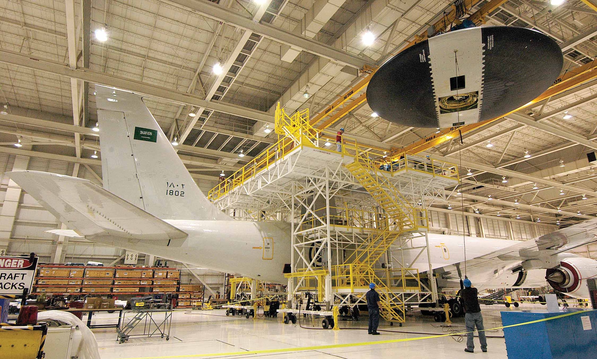 Tinker personnel ease the 30-foot-diameter rotodome from a Royal Saudi Air Force E-3 March 10 in Bldg. 2136.  Mechanics in the 566th Aircraft Maintenance Squadron were lowering the rotodome to a work stand to replace the Antenna Pedestal Turntable.  (Air Force photo by Margo Wright)