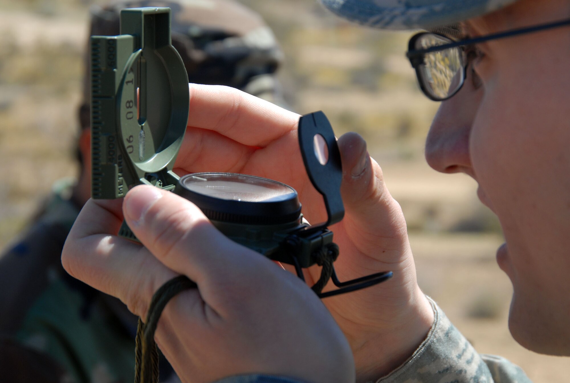 Airman 1st Class Anthony Particini, 95th Aerospace Medical Squadron bioenvironmental engineer, peeps through a compass during land navigation training here March 26. The training included basic understanding of compass use, topographical features, grid coordinates and distance approximation using pace counts. (Air Force photo by Senior Airman Julius Delos Reyes)