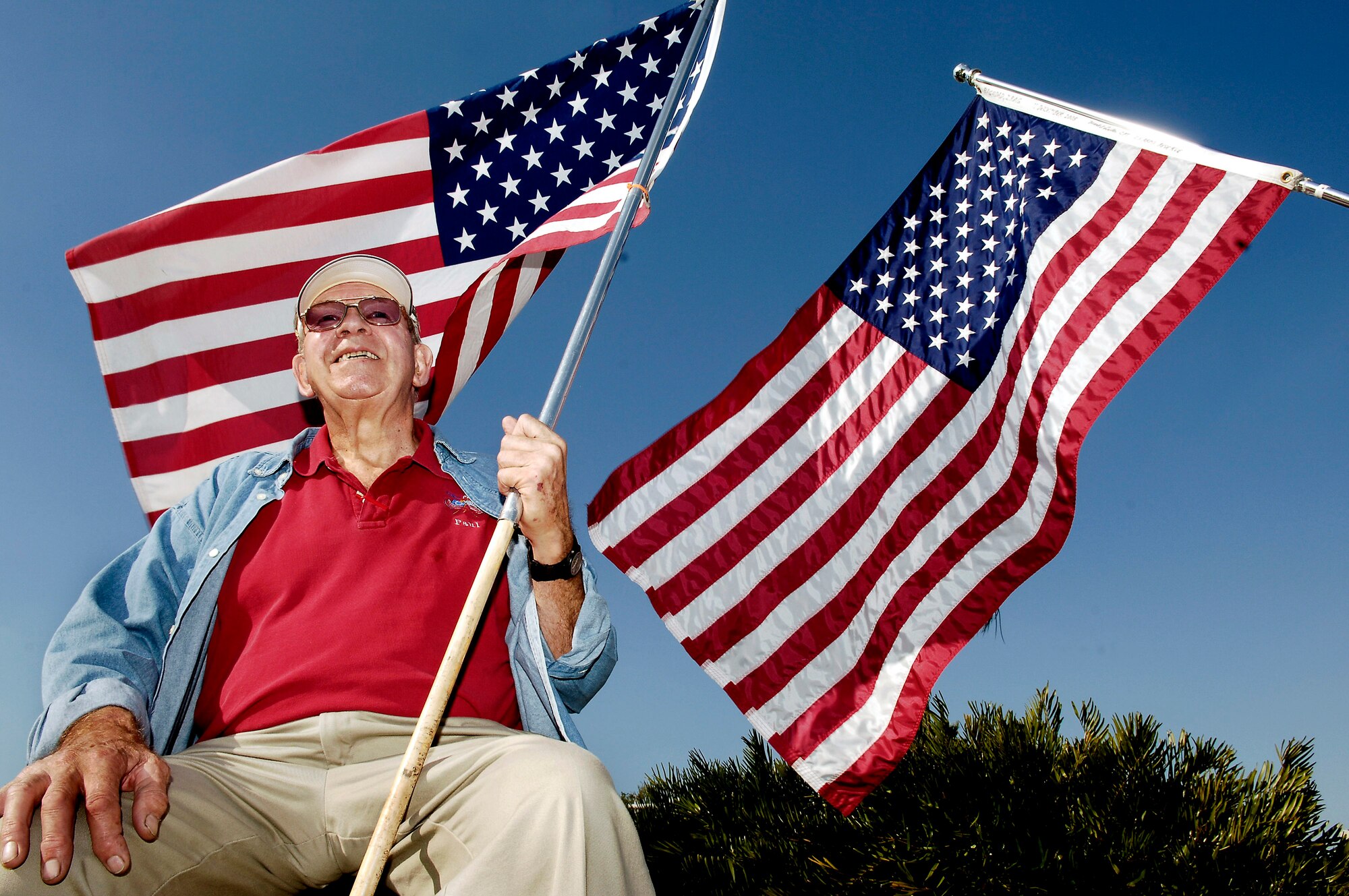 Paul Diehl shows his patriotism to members March 21 at MacDill Air Force Base, Fla. Mr. Diehl is a member of the Bayshore Patriots in Tampa. The patriots show their support to military members and their families by waving the American flag on one of the busy roads in Tampa. They consist of retired military and civilian members of the community.  (U.S. Air Force photo/Senior Airman Bradley Lail)