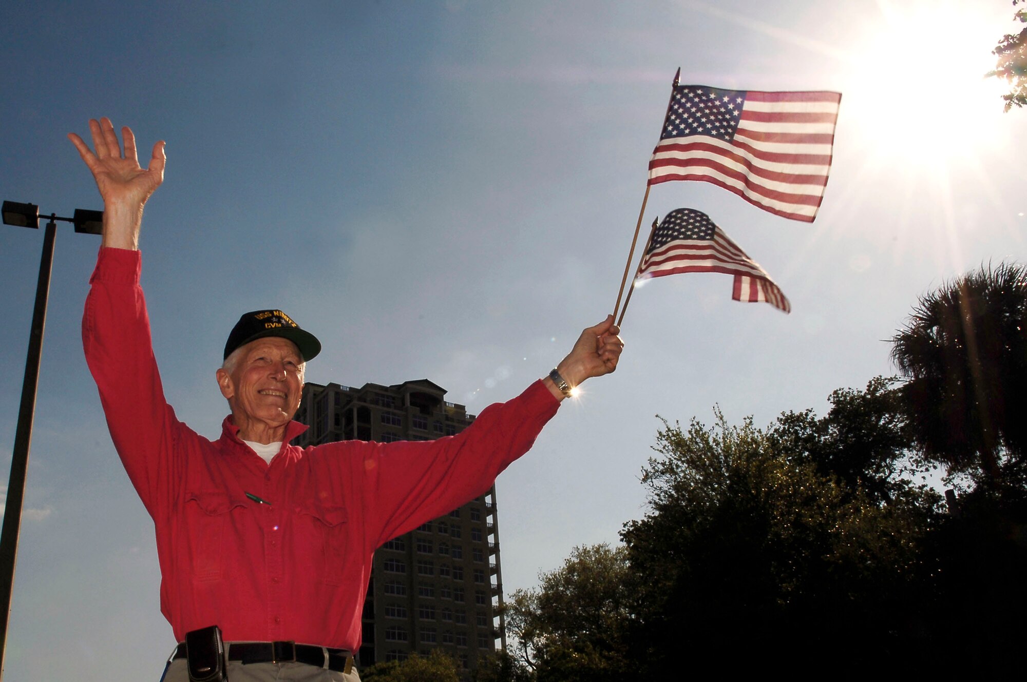 Retired Navy Rear Adm. Leroy Collins Jr. waves to military members March 21 at MacDill Air Force Base, Fla. Admiral Collins is a member of the Bayshore Patriots in Tampa. The patriots show their support to military members and their families by waving the American flag on one of the busy roads in Tampa. They consist of retired military and civilian members of the community.  (U.S. Air Force photo/Senior Airman Bradley Lail) 
