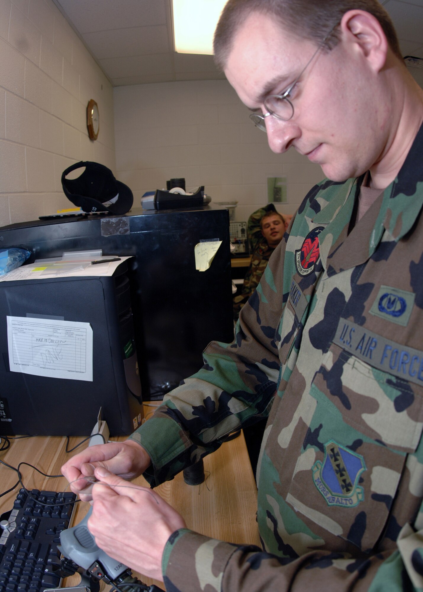 DYESS AIR FORCE BASE, Texas -- Airman 1st Class Jay Baker fastens an oxygen mask's straps March 27. The mask's straps are sewn together to prevent the mask from leaking oxygen. (U.S. Air Force Photo by Airman 1st Class Micheal Breaux)