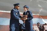 Outgoing 12th Flying Training Wing commander, Col. Richard Clark, passes the ball of command to his successor, Col. Jacqueline Van Ovost, during a change of command ceremony March 14 at Randolph Air Force Base, Texas. (U.S. Air Force photo by Joel Martinez)