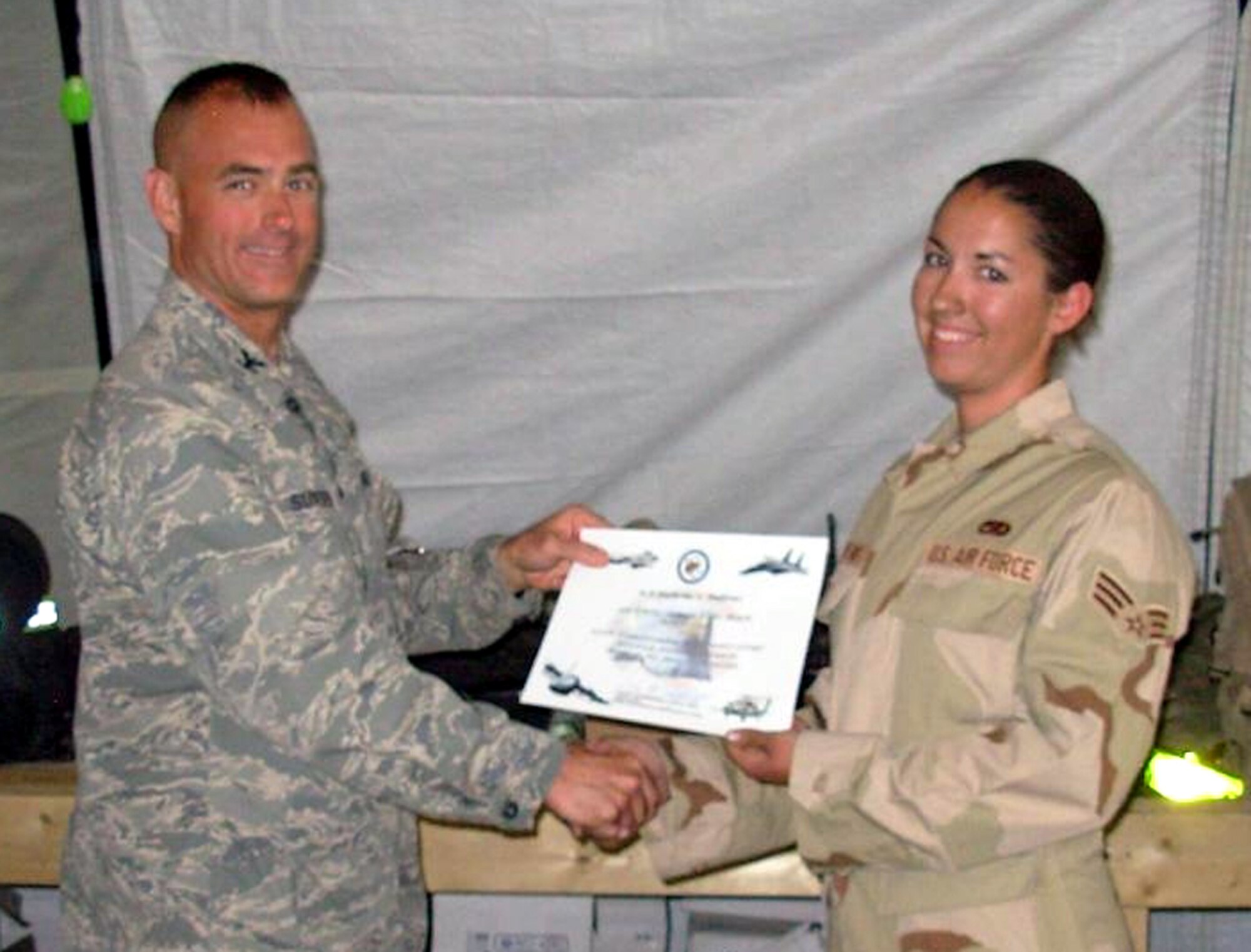 BAGRAM AIR BASE, Afghanistan -- Col. Jon Sutterfield, 455th Expeditionary Maintenance Group commander, presents Senior Airman Katherine Andrews, 455th Expeditionary Aircraft Maintenance Unit, a certificate for being named the 455th Air Expeditionary Wing airman of the month. Airman Andrews is deployed from Spangdahlem Air Base, Germany. (U.S. Air Force photo)