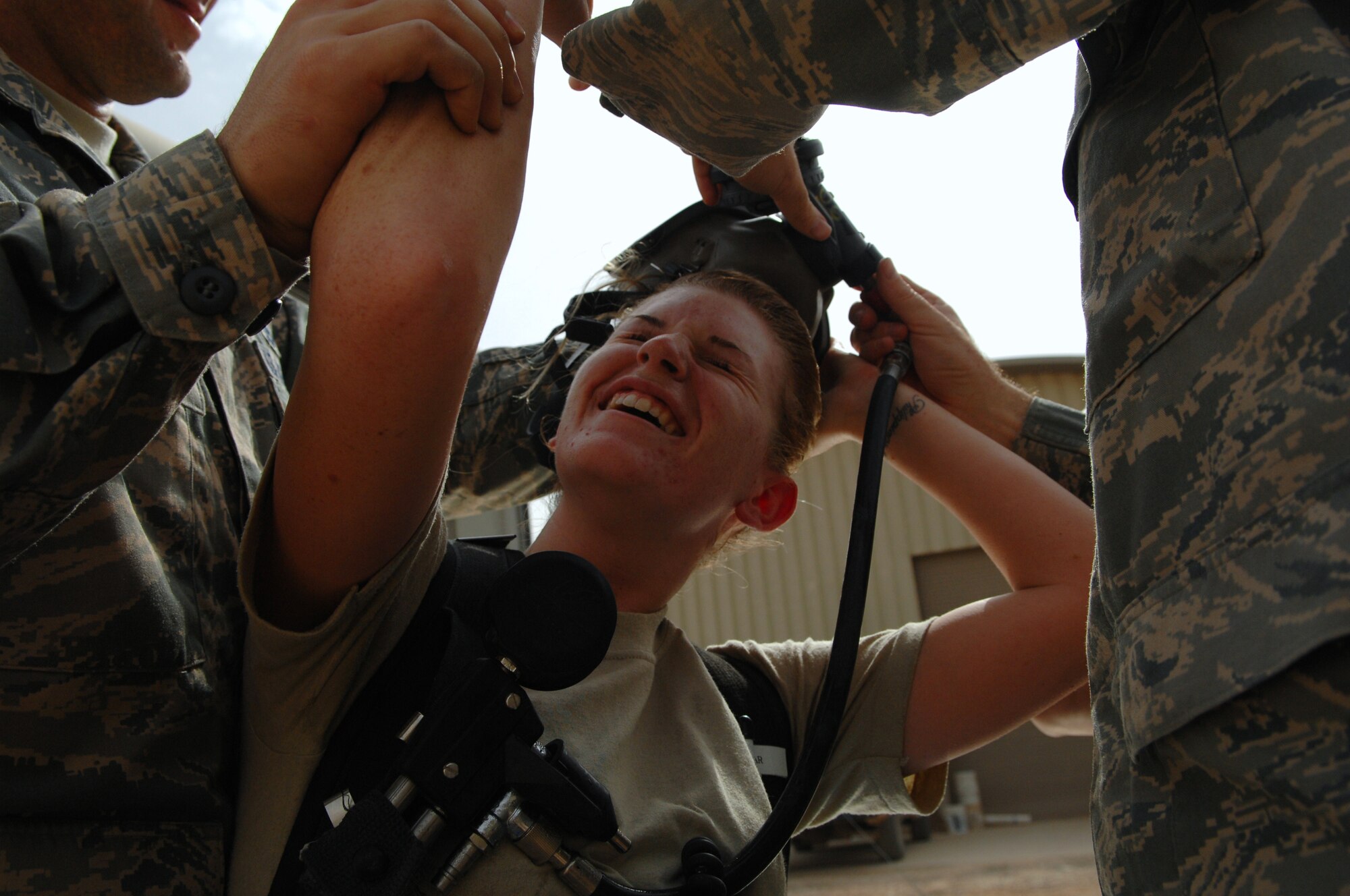 BALAD AIR BASE, Iraq -- Senior Airman Krista McVicar, 332nd Expeditionary Civil Engineer Squadron emergency manager, removes her oxygen mask after a battle drill here, March 26. Wearing an oxygen mask and protection suit for an extended period of time is a challenge for even the fittest Airman. Battle drills help emergency management Airmen condition their bodies and hone their skills. Airman McVicar is deployed from Davis-Monthan Air Force Base, Ariz. (U.S. Air Force photo/ Senior Airman Julianne Showalter)