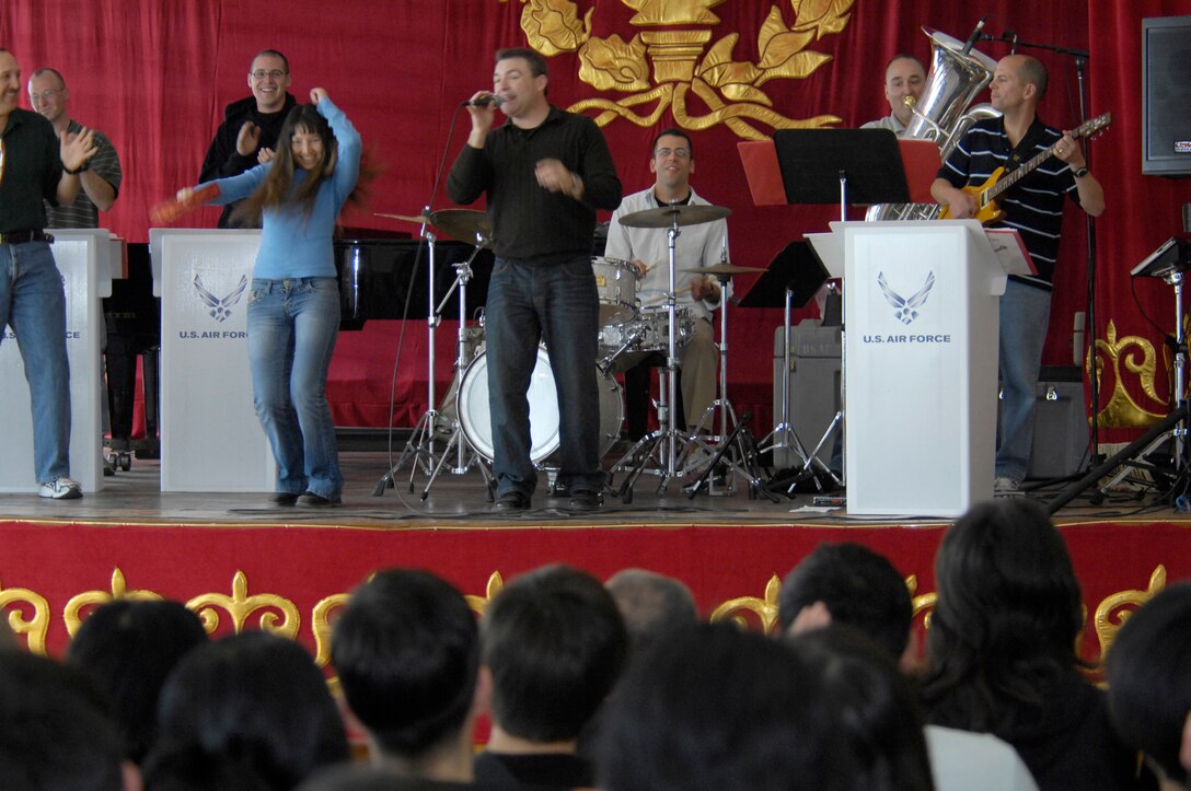 Gulia Aidaralieva, a student of the Bishkek College of Music in Kyrgyzstan, plays the tambourine with the U.S. Air Forces Central Band "Hot Brass" during their performance at the school on March 26, 2008. The USAF pop band performed at the Bishkek College of Music as well other locations off-base during their six-day trip to Kyrgyzstan.(Air Force photo by Senior Airman Tabitha Kuykendall) 