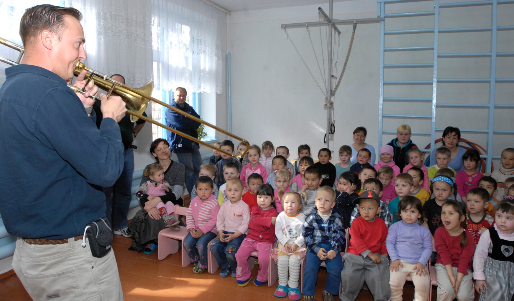 Master Sergeant Rick Thorp, a trombone player with the U.S. Air Forces Central Band "Hot Brass," introduces the students of the village school in Vasilievka, Kyrgyzstan to his instrument on March 26, 2008. Each band member took the time to introduce the students to their instruments before putting them together in harmony to make music.  "Hot Brass" performed for Manas Air Base Airmen and at numerous off-base locations during their six-day trip to Kyrgyzstan. (Air Force photo by Senior Airman Tabitha Kuykendall) 