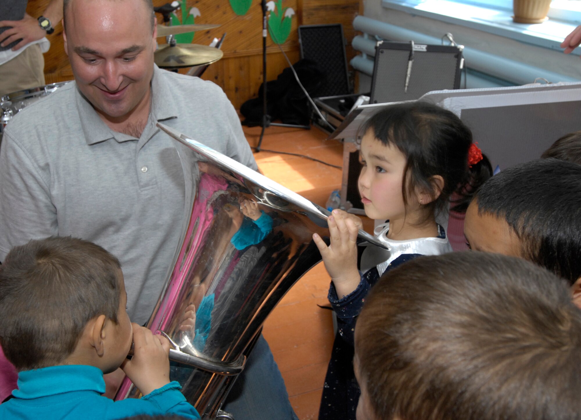Staff Sergeant Matt Kuebler, a tuba player with the U.S. Air Force Central Band "Hot Brass," shows children in Vasilievka, Kyrgyzstan his instrument during a visit to their school on March 26, 2008. Each band member took the time to introduce the students to each instrument before putting them together in harmony to make music.  "Hot Brass" performed for Manas Air Base Airmen and at numerous off-base locations during their six-day trip to Kyrgyzstan. (Air Force photo by Senior Airman Tabitha Kuykendall) 
