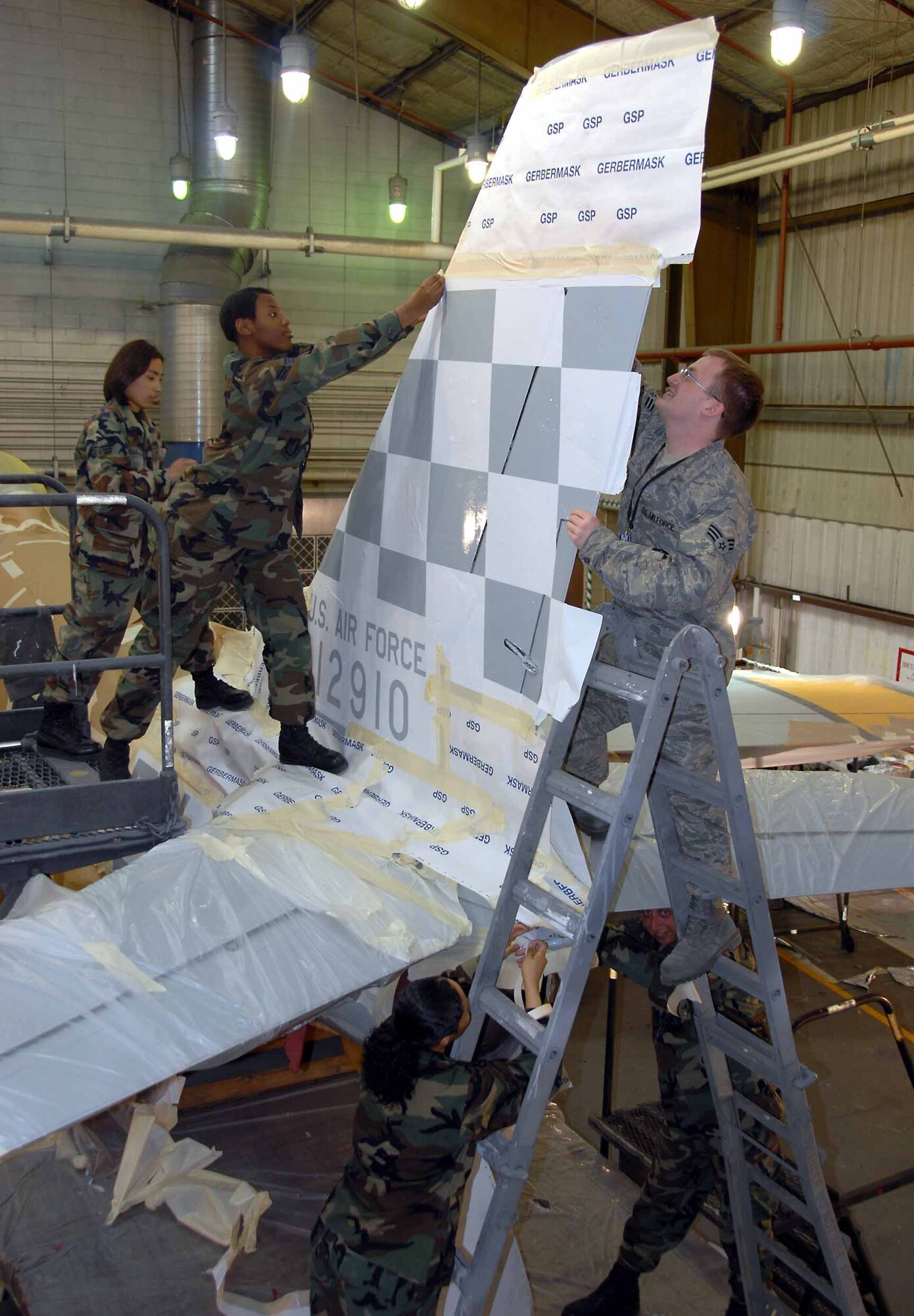 OSAN AIR BASE, Republic of Korea -- 51st Maintenance Squadron aircraft structural technicians prepares Osan's historic F-86 Sabre static display aircraft for restoration and a new "checkertail" paint scheme. Only the most experienced technicians are entrusted to apply the “checkertail” design. (U.S. Air Force photo/Senior Master Sgt. Marvin Krause)  
