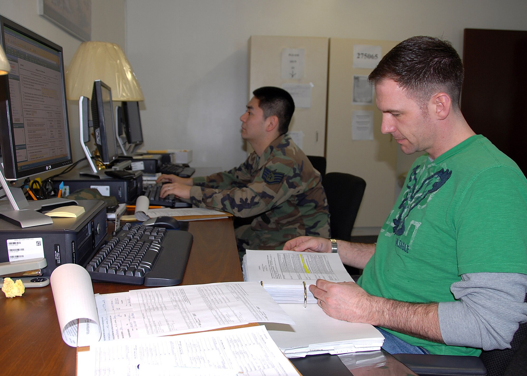 MISAWA AIR BASE, Japan -- Staff Sgt. Alex Grupp (front) and Staff Sgt. Michael Oyakawa (back), both members of the 35th Maintenance Group and volunteers at the base tax center, use file taxes online for Misawa residents Feb. 29, 2008. The tax center is staffed by volunteers and files taxes for servicemembers at no cost. (U.S. Air Force photo by Senior Airman Chad Strohmeyer)
