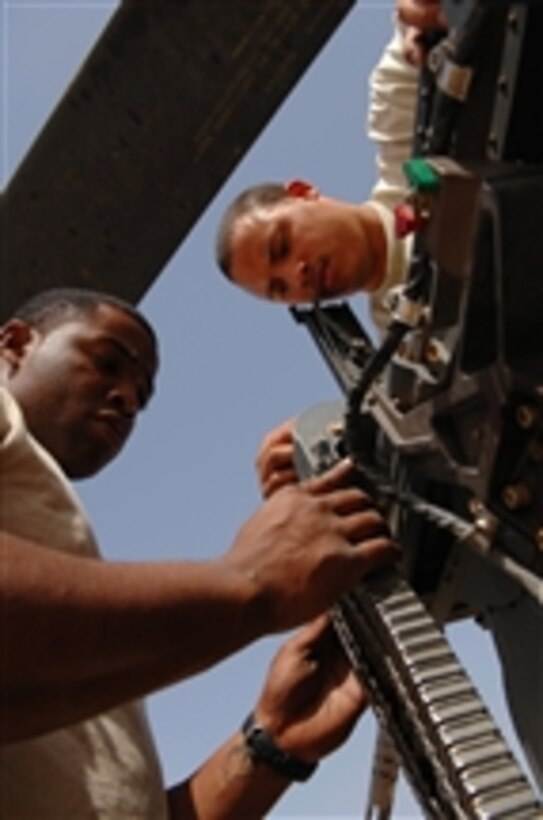 U.S. Air Force Senior Airmen Derand Javier and Chris Moore, both weapons specialists with the 64th Aircraft Maintenance Unit, test the head spacing of a .50-caliber machine gun on an HH-60G Pave Hawk helicopter at Balad Air Base, Iraq, on March 25, 2008.  Both airmen are deployed from Moody Air Force Base, Ga.  